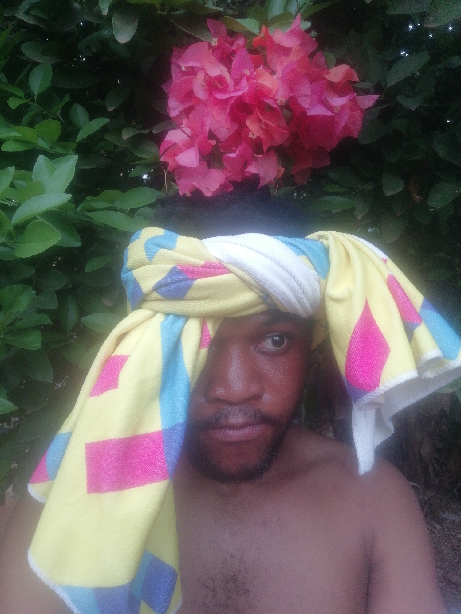 Man poses with colorful bougainvillea flowers in Ikorodu garden