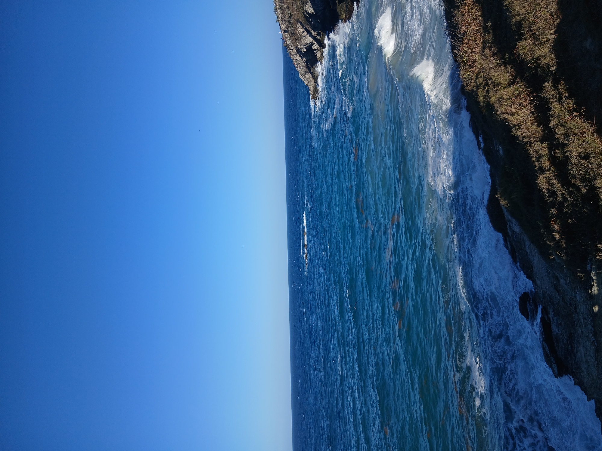 Visitors gather at clifftop viewpoints overlooking Playa Parguito beach