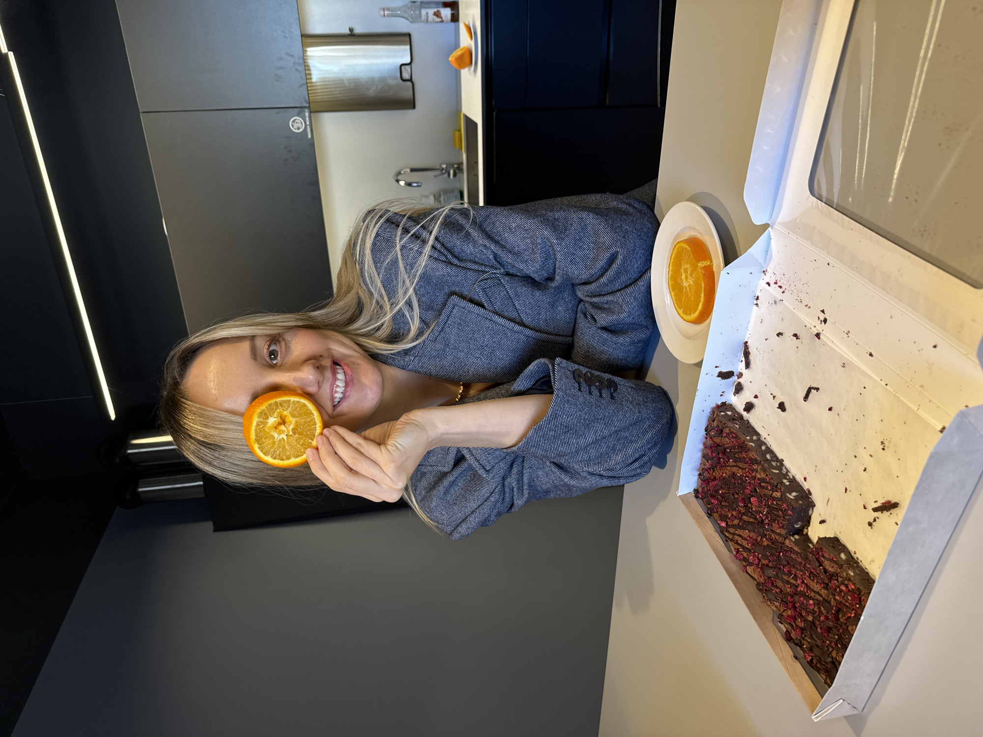 Woman playfully poses with orange slice in Riga cafe