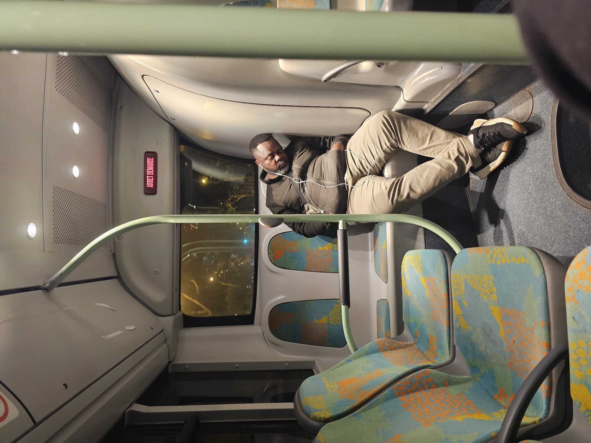 Man rests on bus seats in early morning Paris