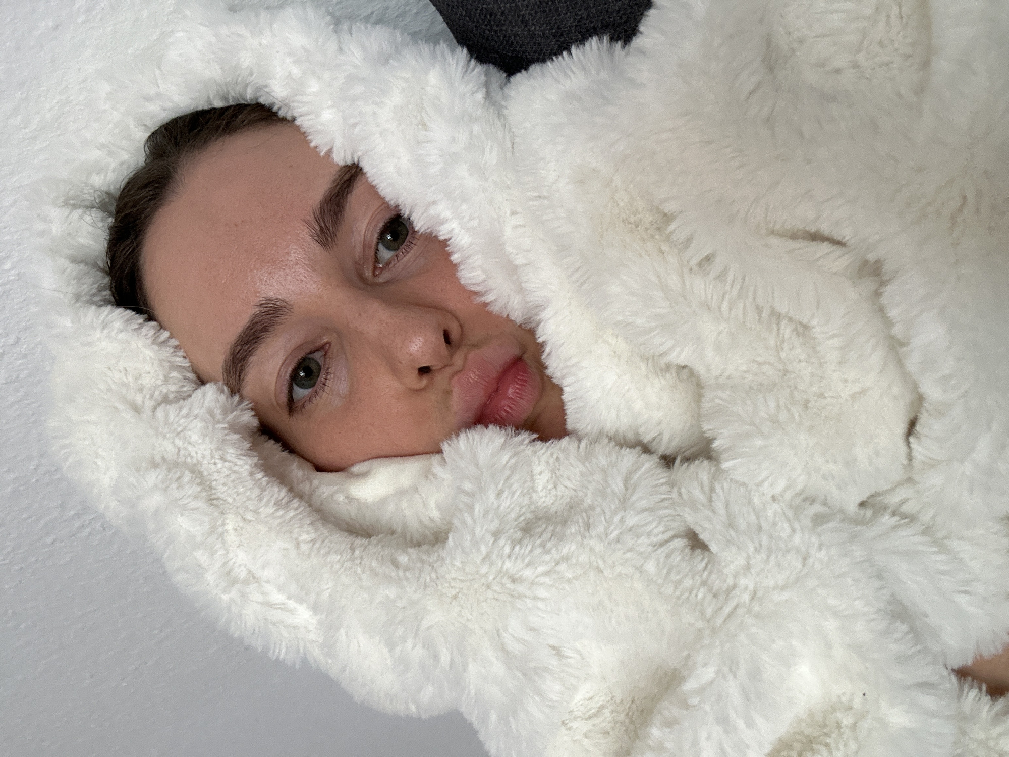 Person photographed wrapped in white fluffy material in Kiel