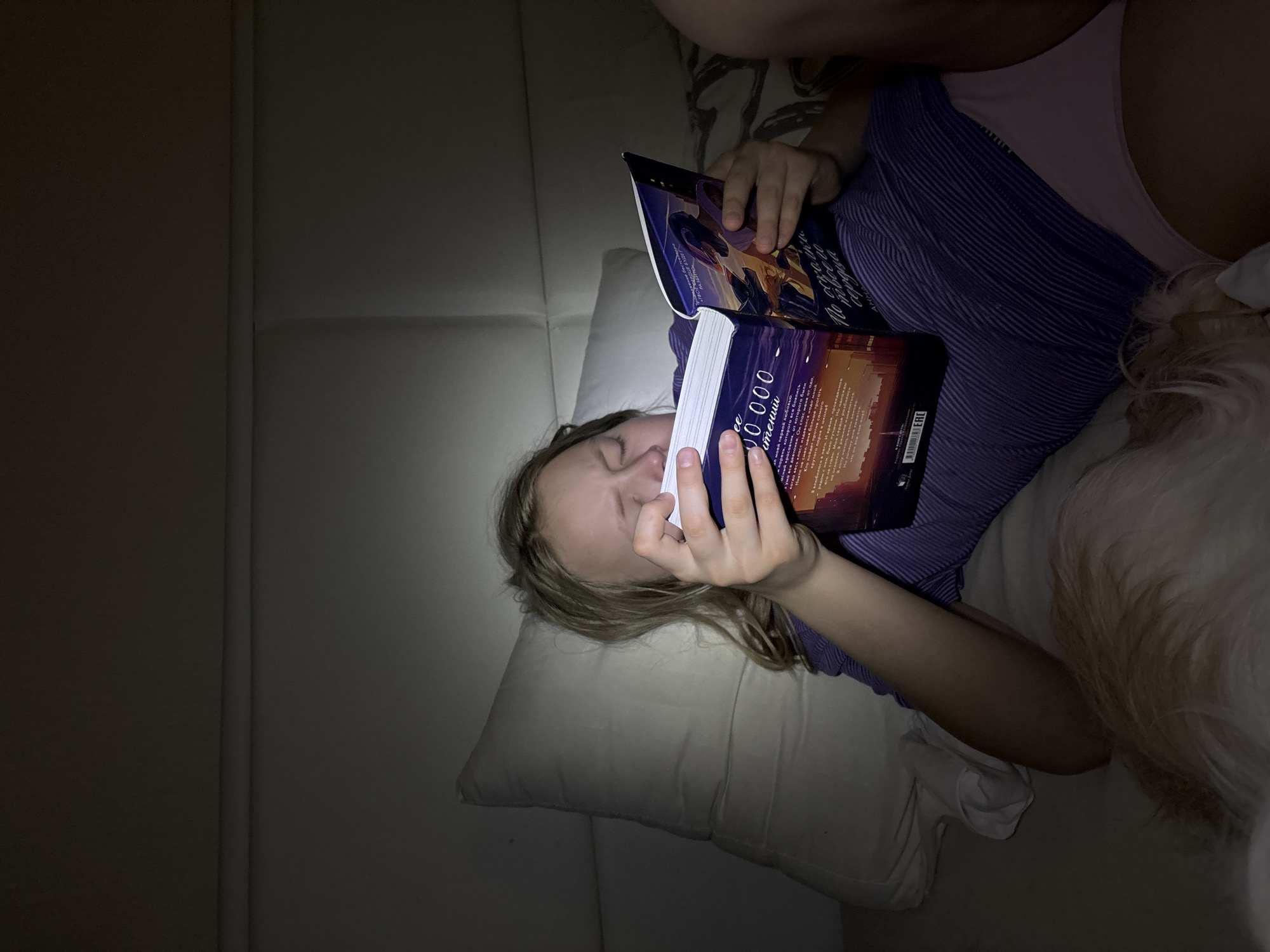 Girl reads Cyrillic book on couch in Izhevsk