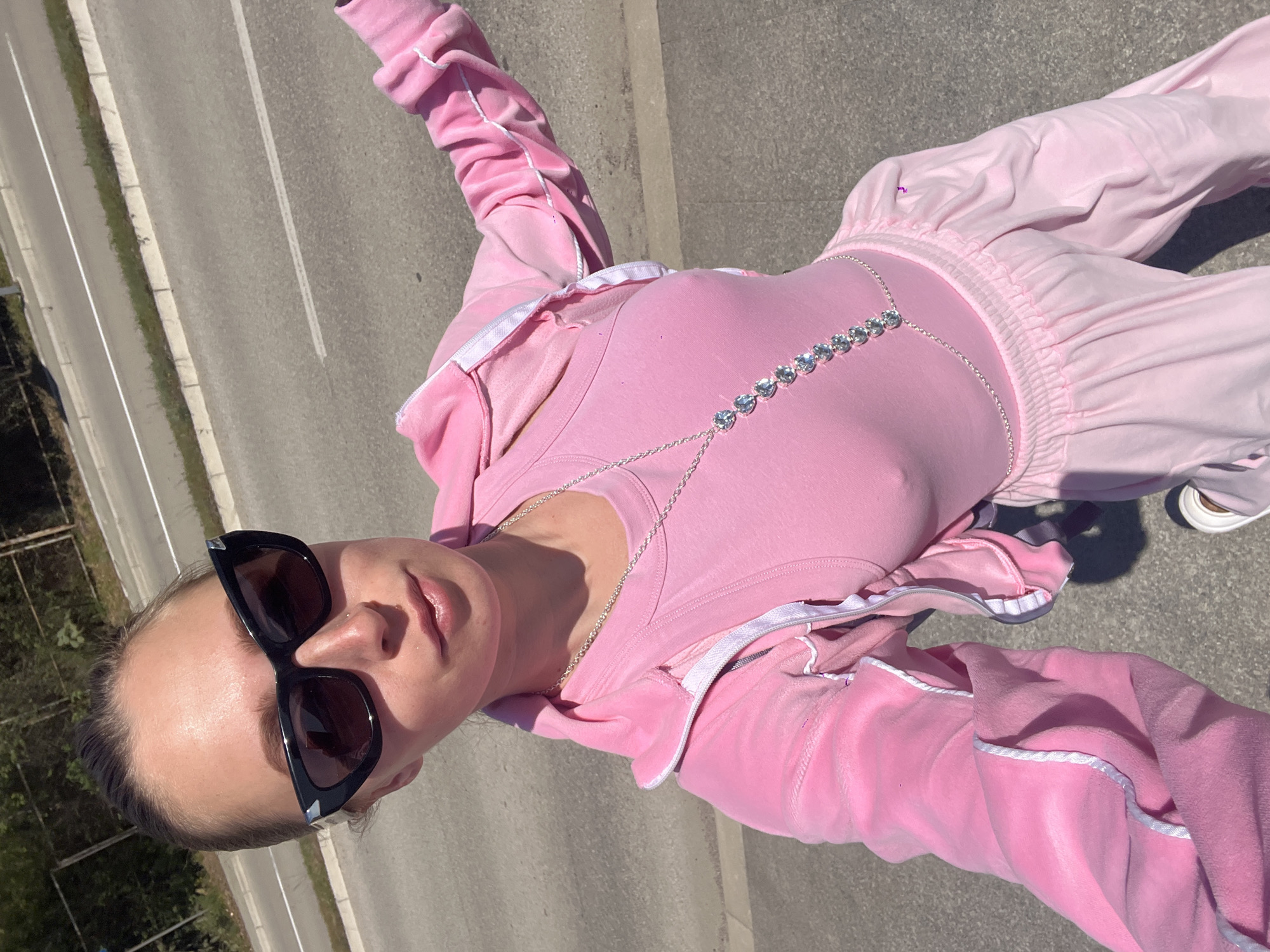 Person takes selfie on road in Montenegro wearing pink tracksuit