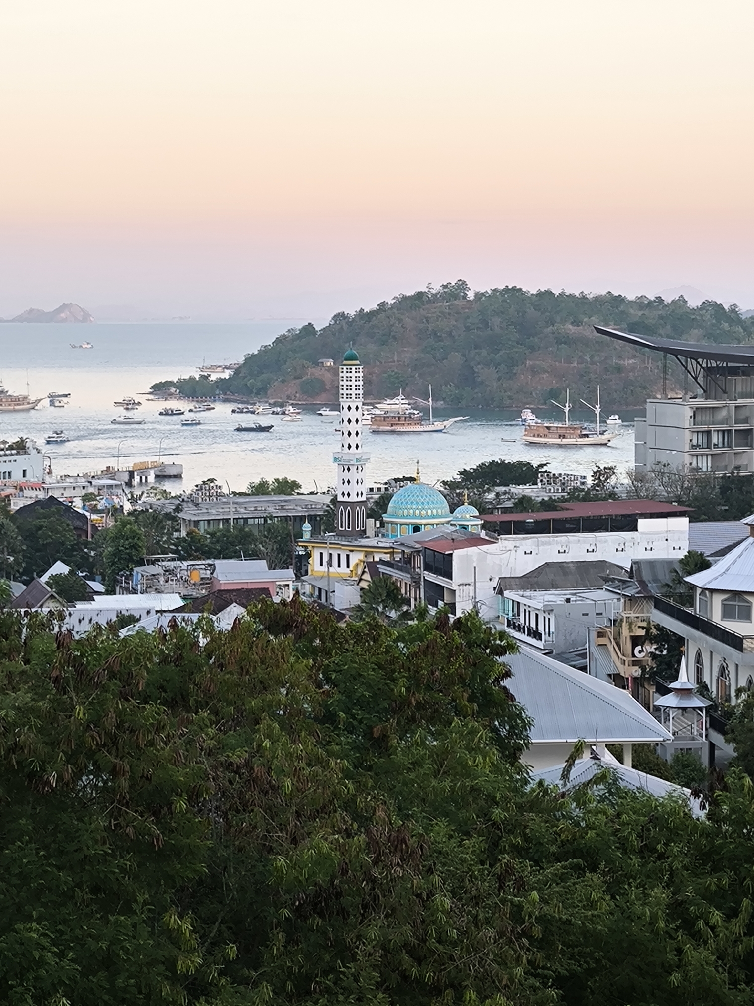 Labuan Bajo harbor at golden hour, boats and islands