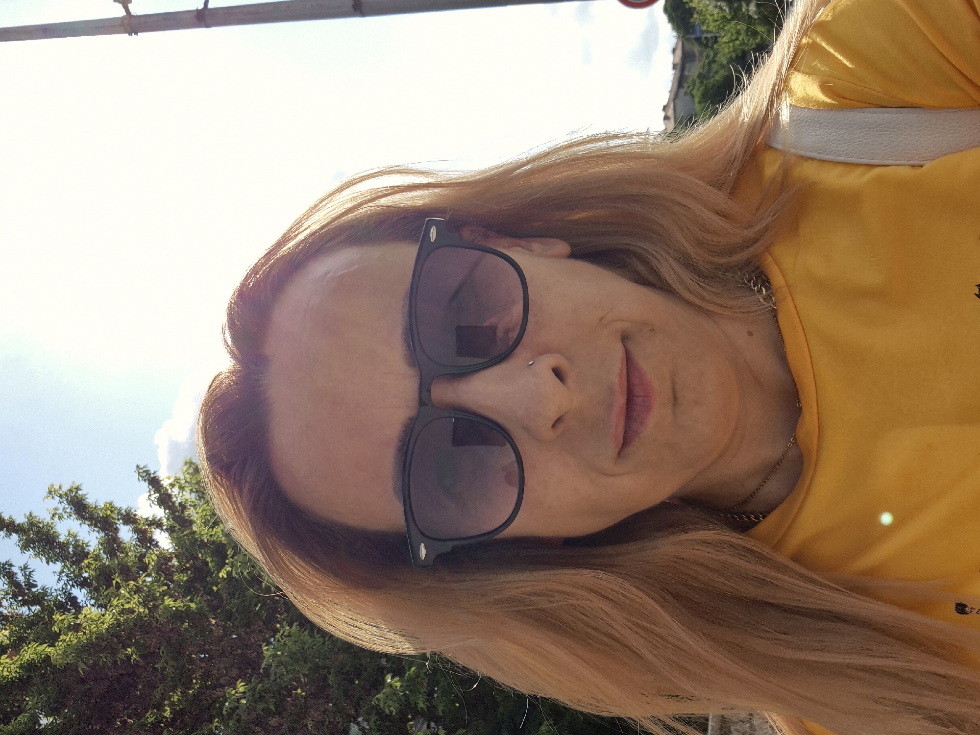 Woman documents sunny afternoon walk with selfies and flower photography