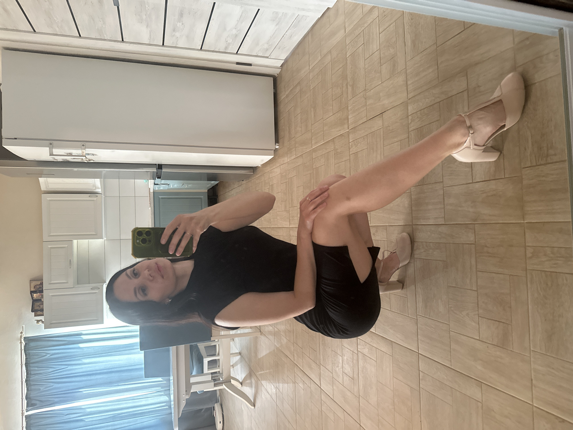Woman takes mirror selfies in kitchen dining area