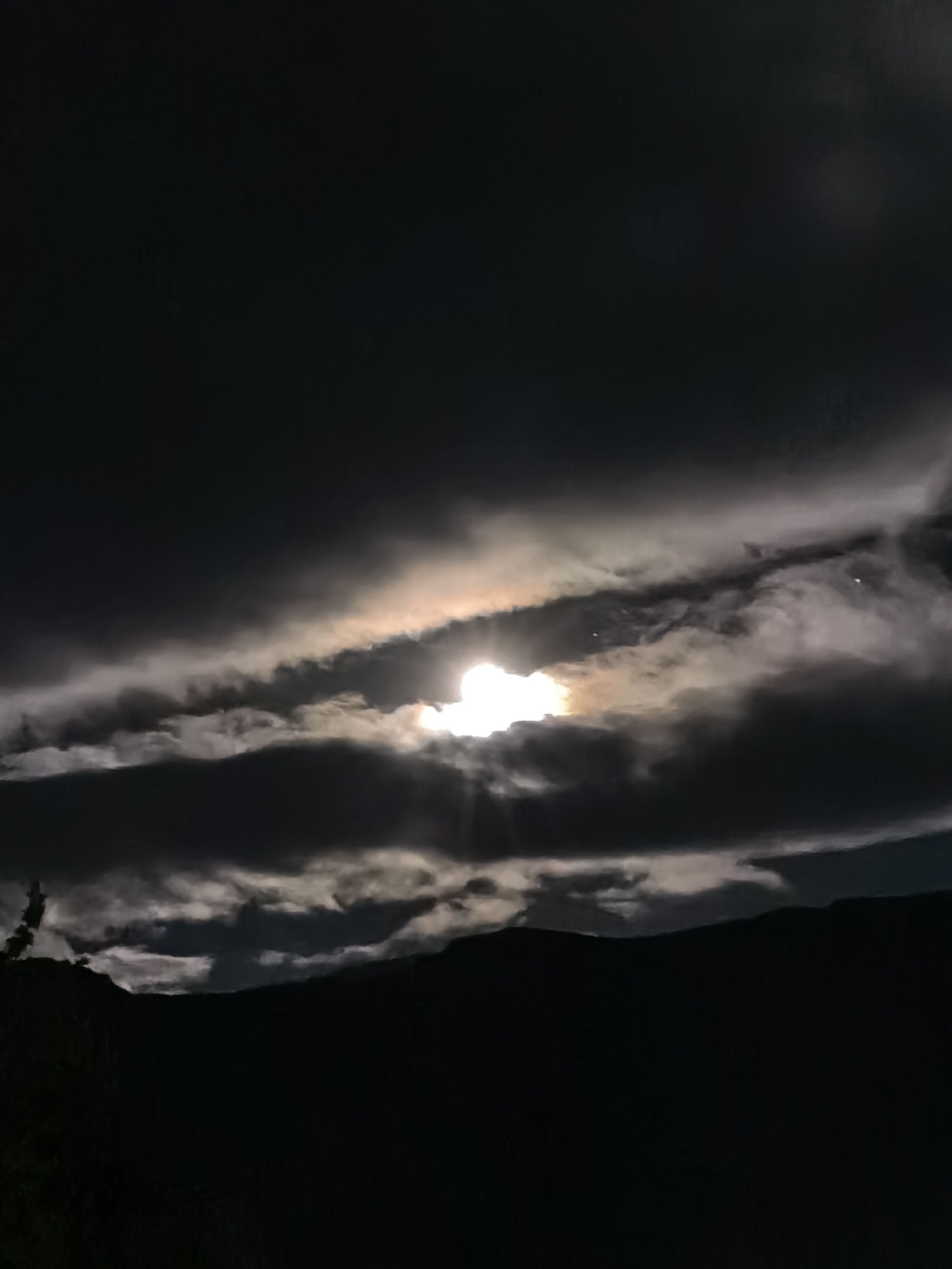 Moon partially obscured by layered clouds observed in Bulgaria