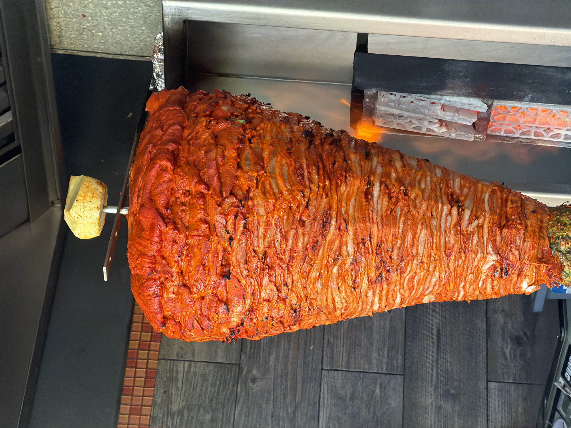 Al pastor trompo in action at a busy Cancún taqueria