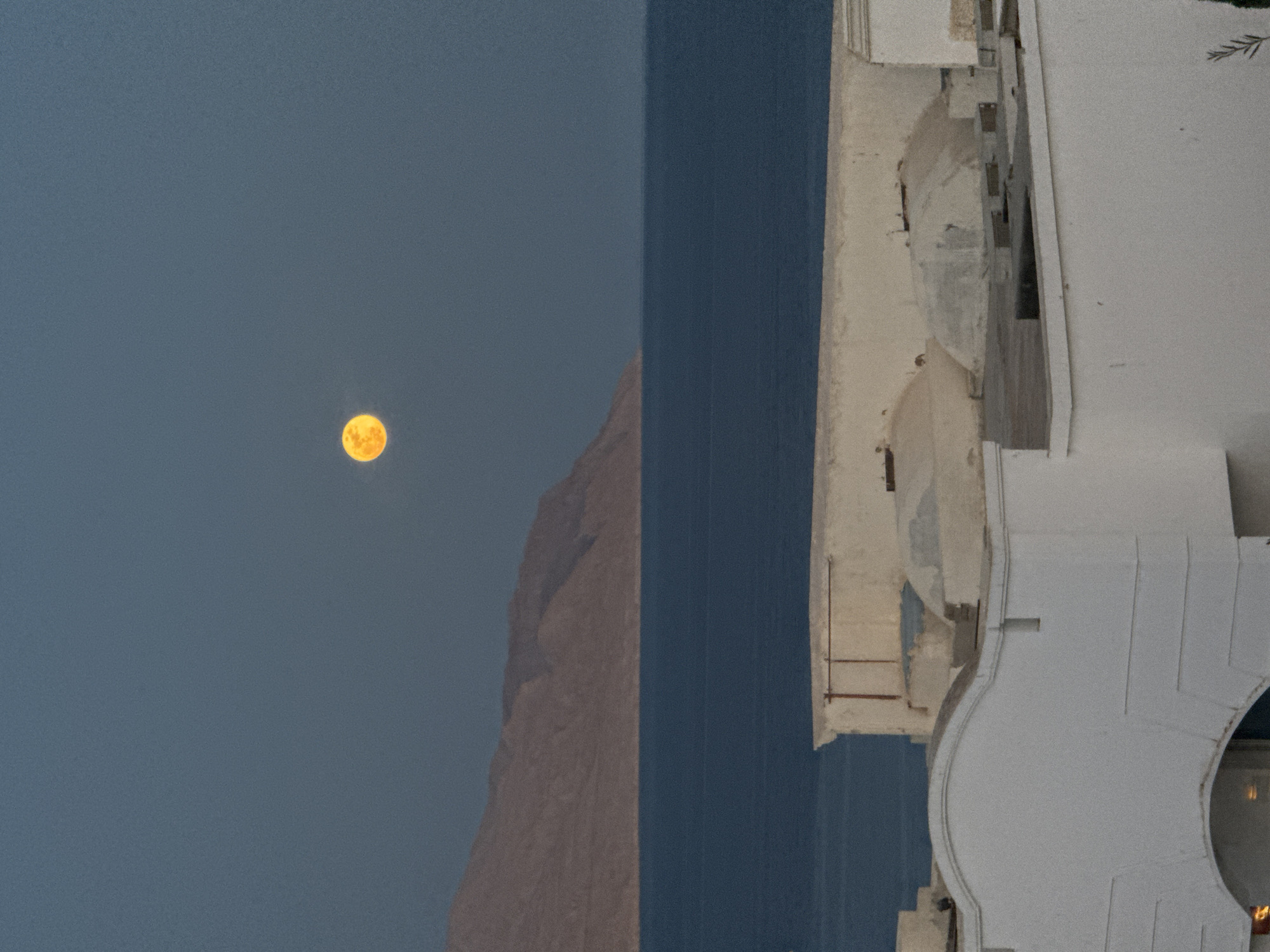 Woman smoking on balcony during full moon in Sharm El Sheikh