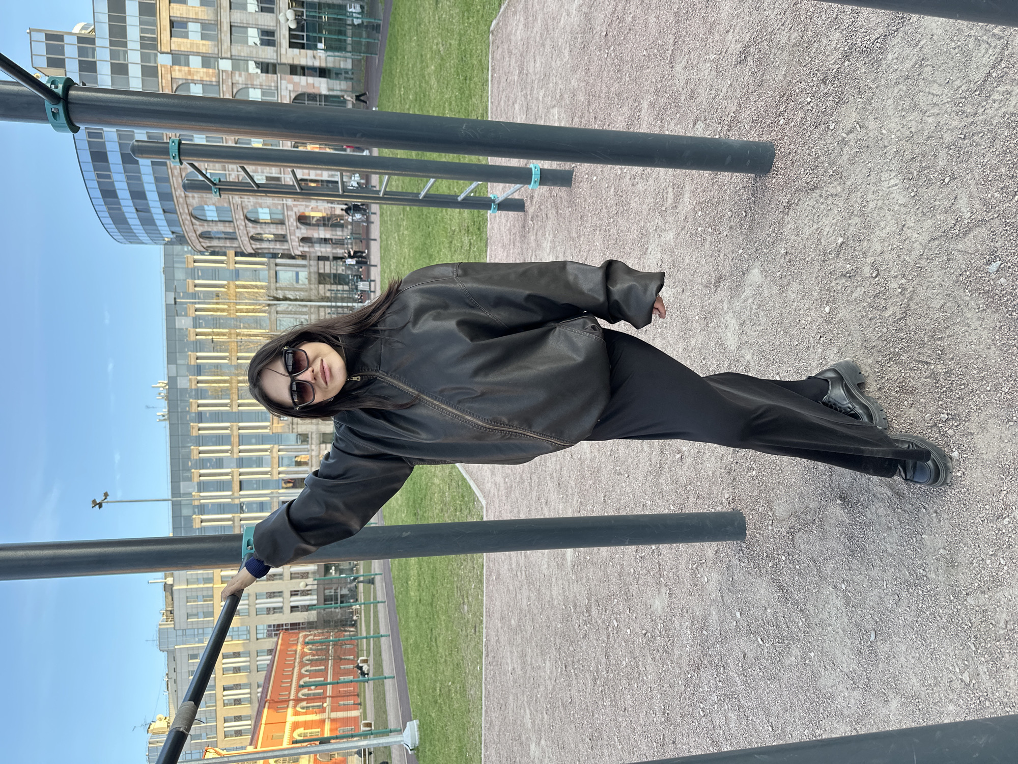 Woman poses at calisthenics bars in Saint Petersburg park