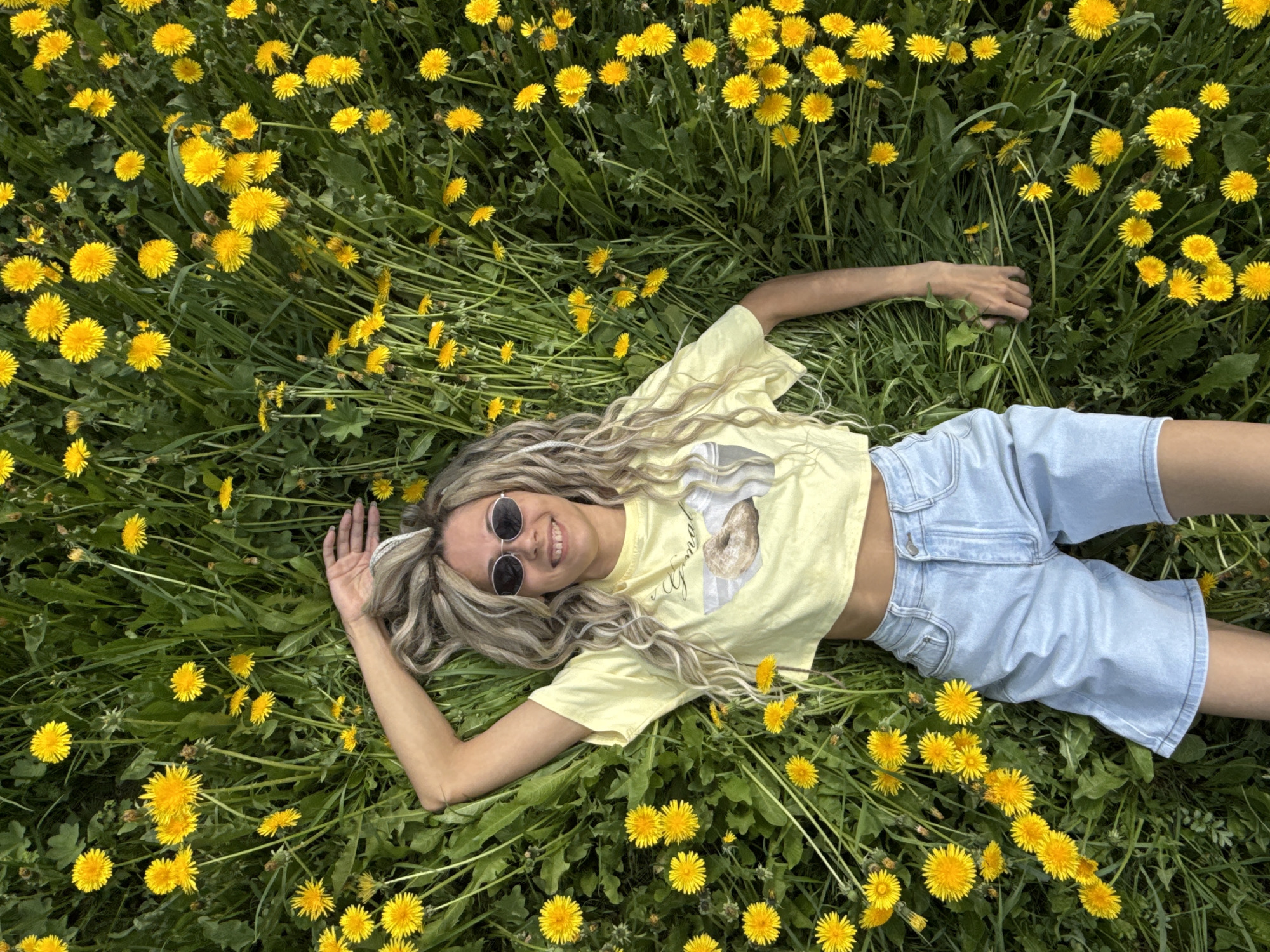 Woman enjoys peaceful moment in blooming dandelion field