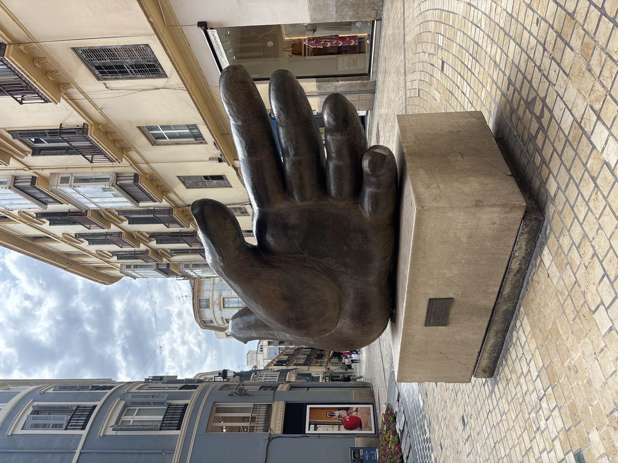 Bronze hand sculpture spotted on Málaga pedestrian street