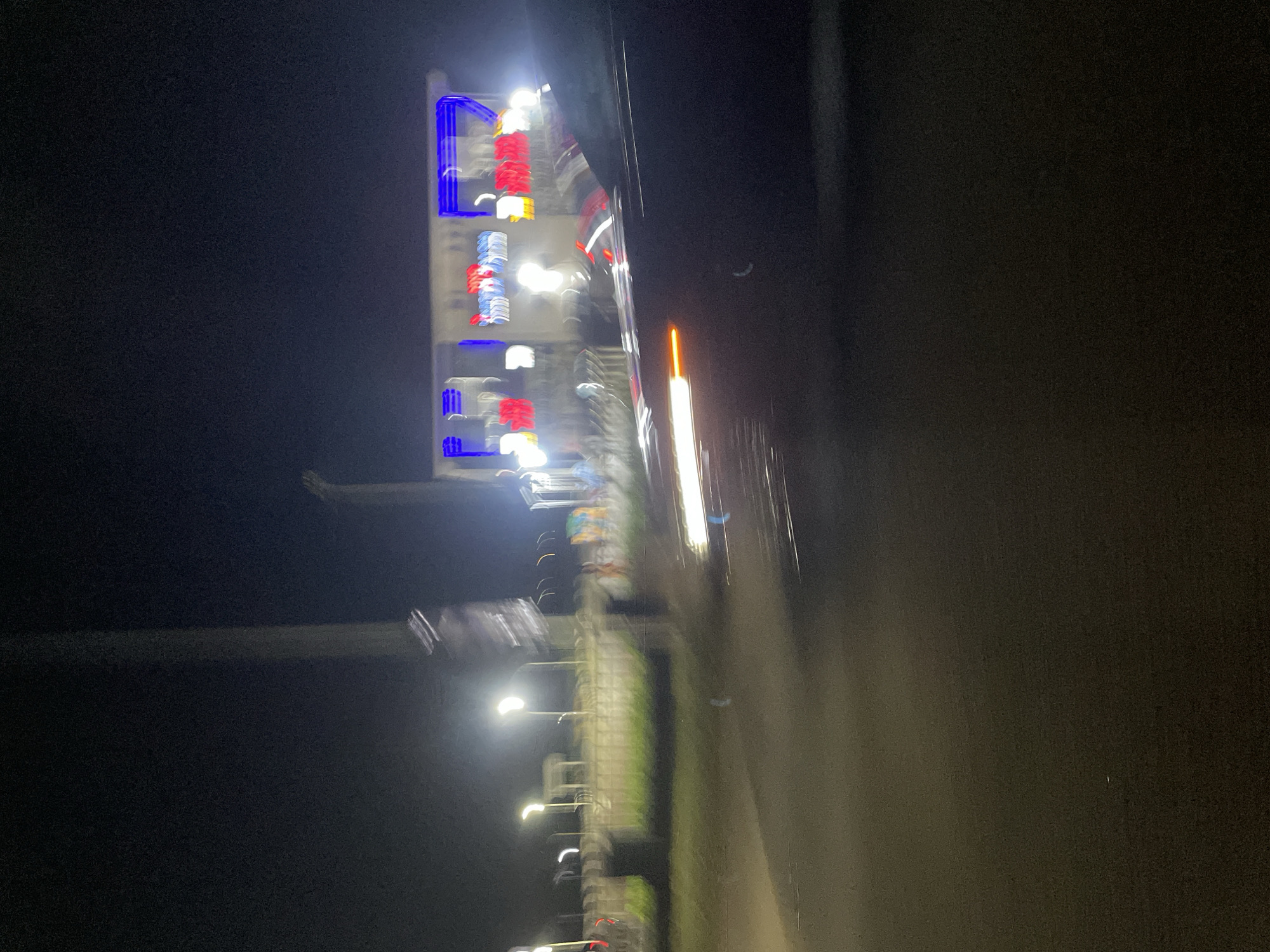 Motorcyclist rides through nighttime Abuja streets near Skyview Hotel