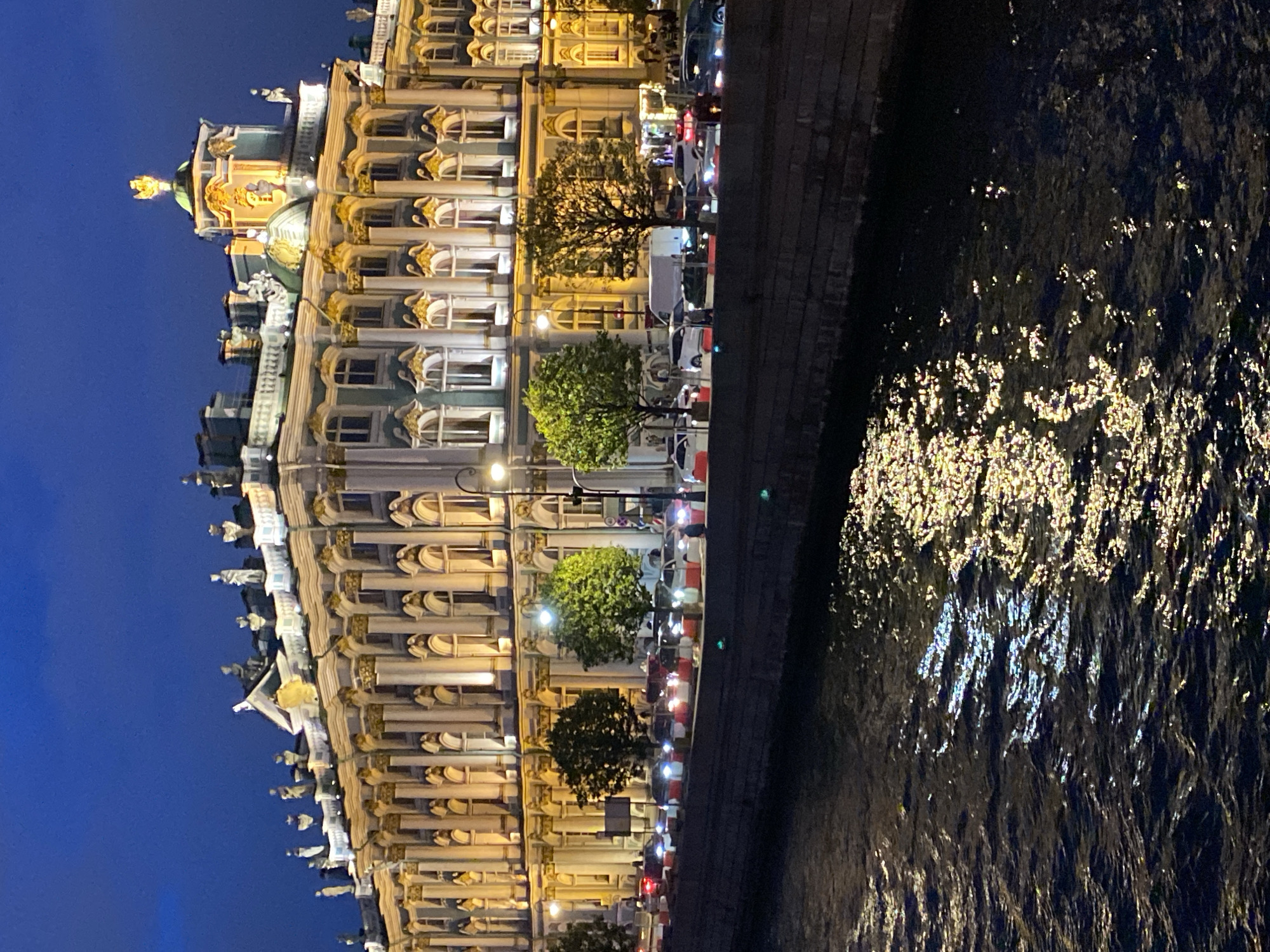 Winter Palace glowing at night across the Neva River