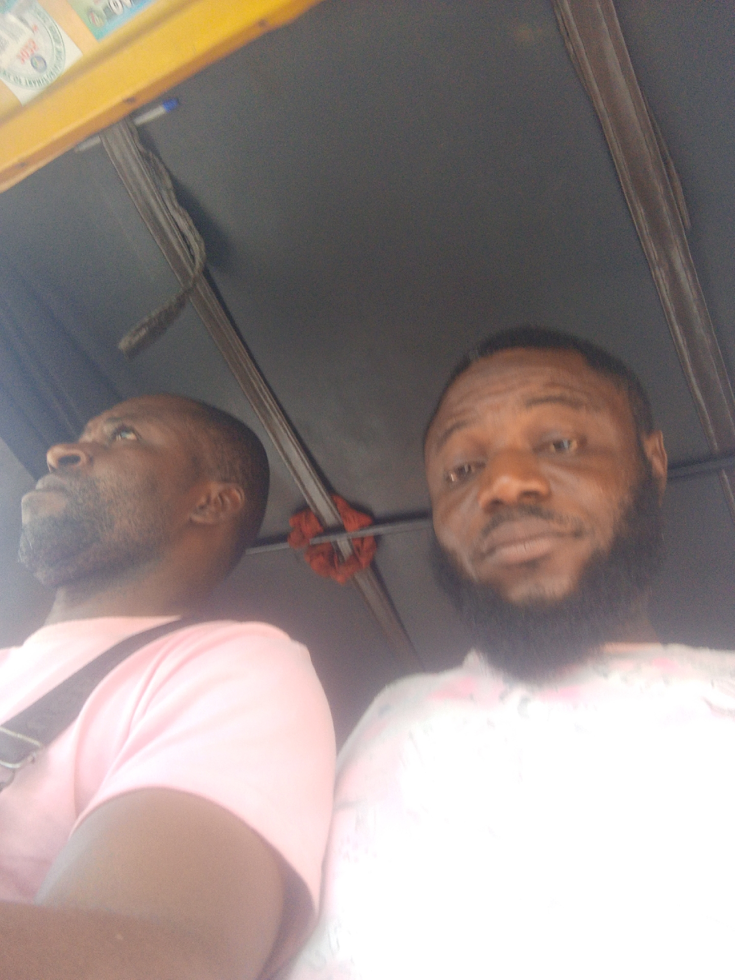 Two men travel by auto rickshaw in urban area