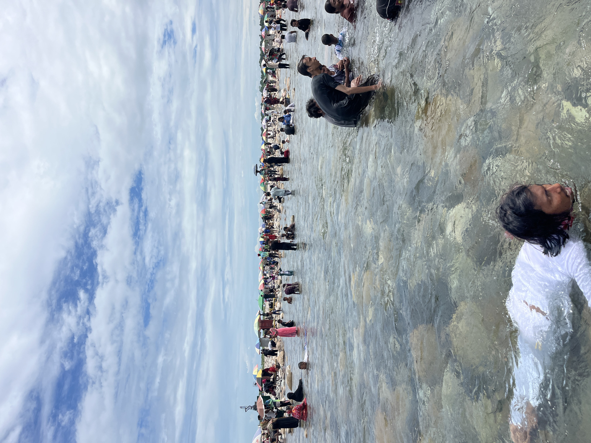 Crowds wade in River Titas during a riverside gathering in Majai