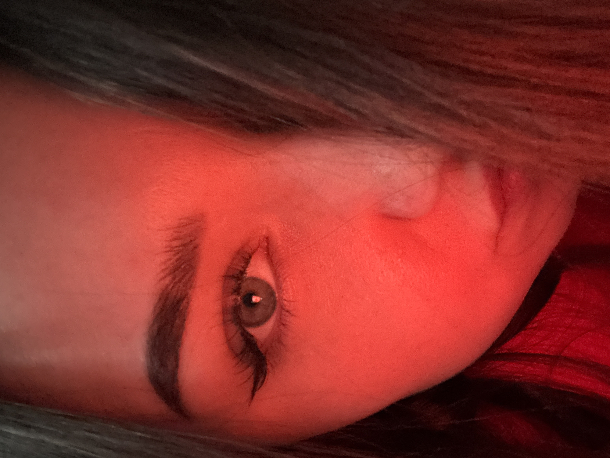 Person photographed with energy drink under red lighting