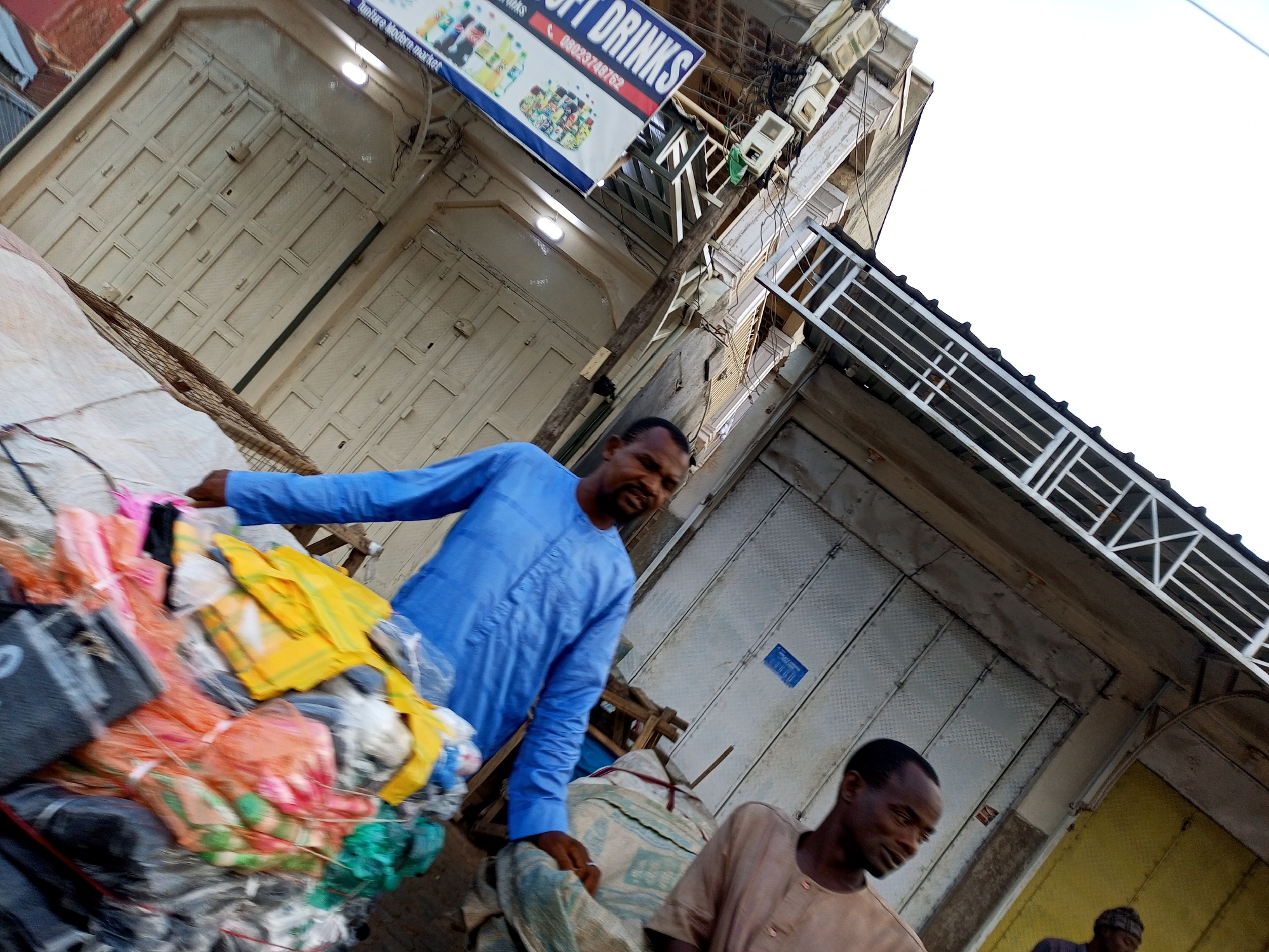 Busy street market with bags, goods, and people moving around