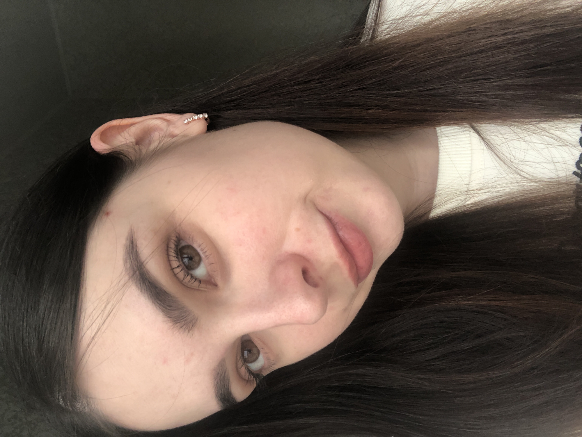 Woman photographed wearing white sweater, decorative ear cuff in Russia