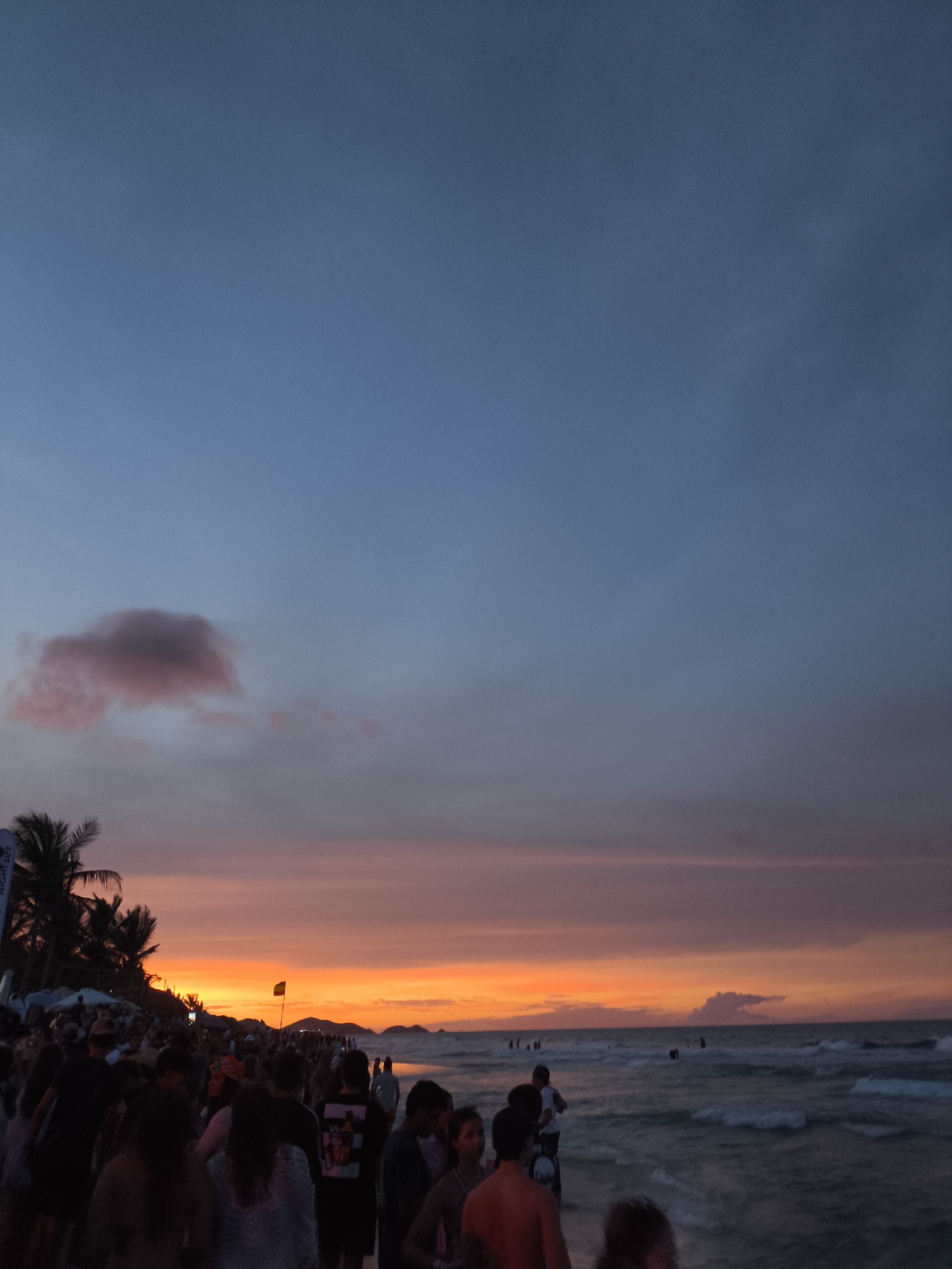 Evening crowds gather at Playa Parguito beach during sunset