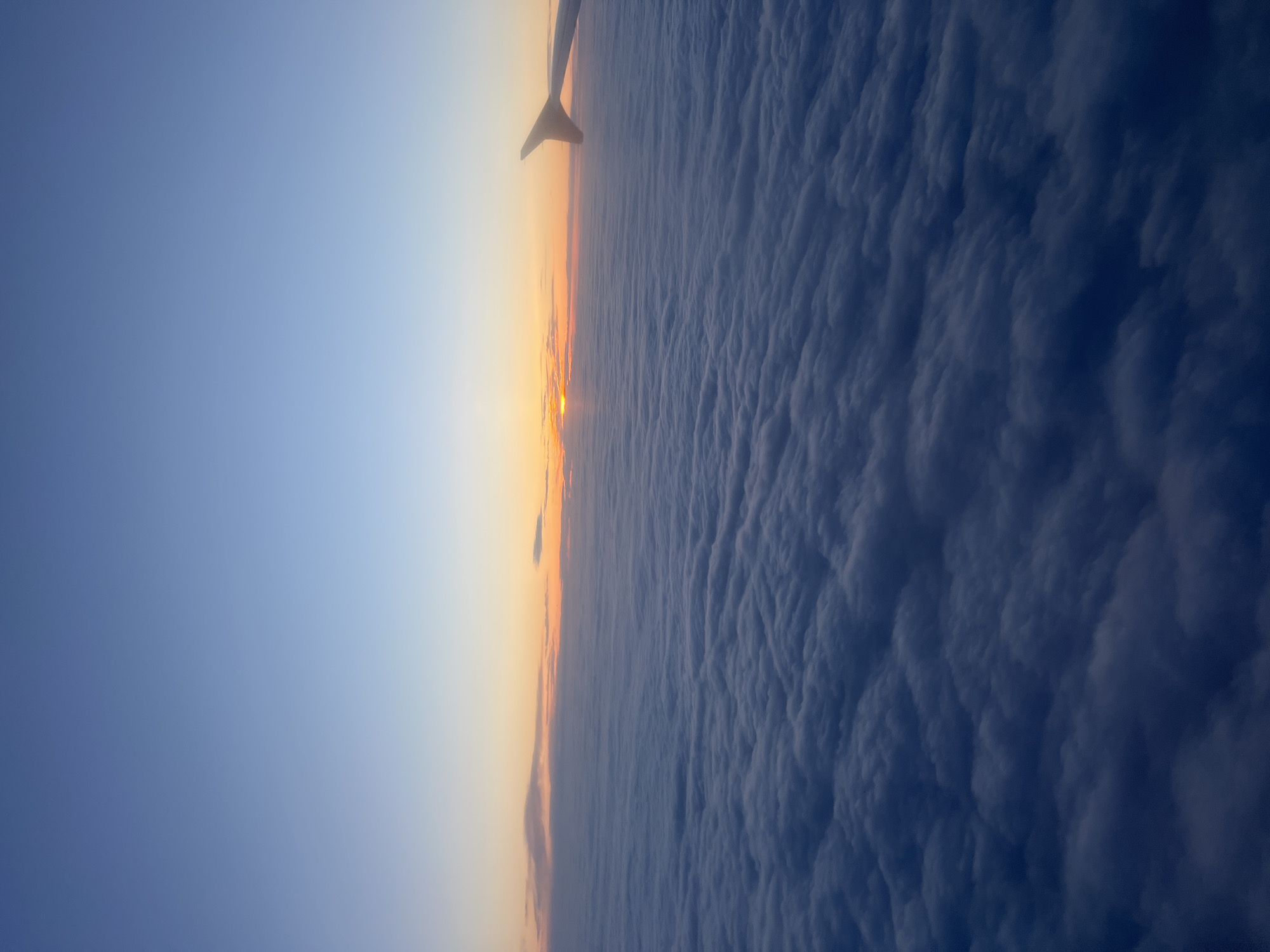 Airplane wing photographed from window over Moldova at sunset