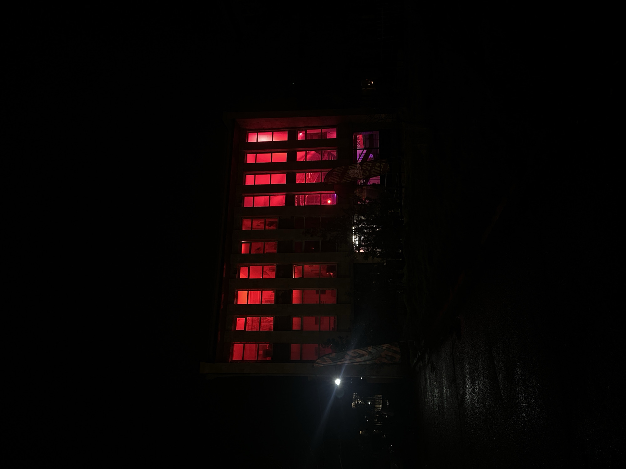 Building windows glow red-purple in nighttime Yerevan
