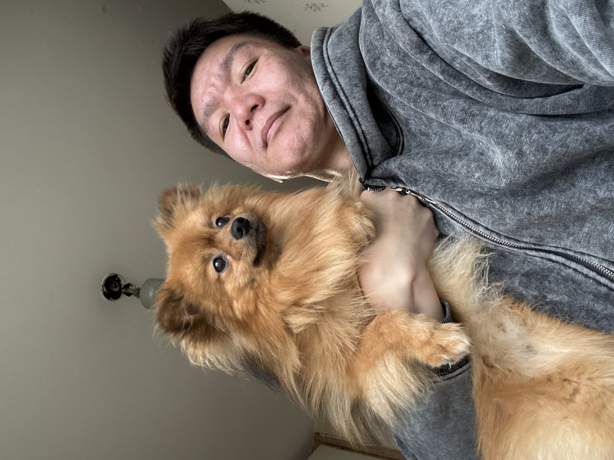 Man photographed with Pomeranian dog at home in Khimki