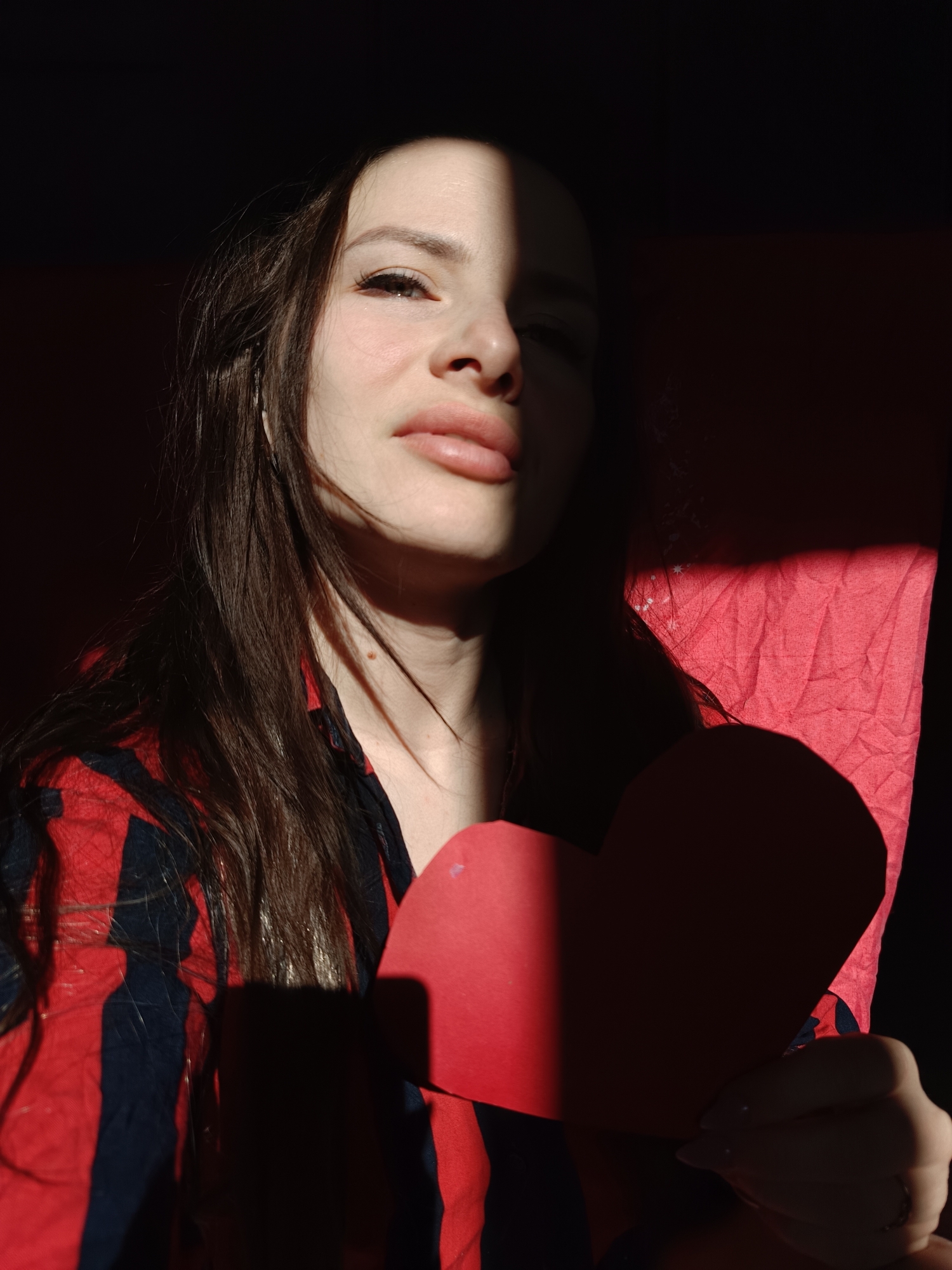 Woman poses with heart-shaped cards and cat in Rusalevka