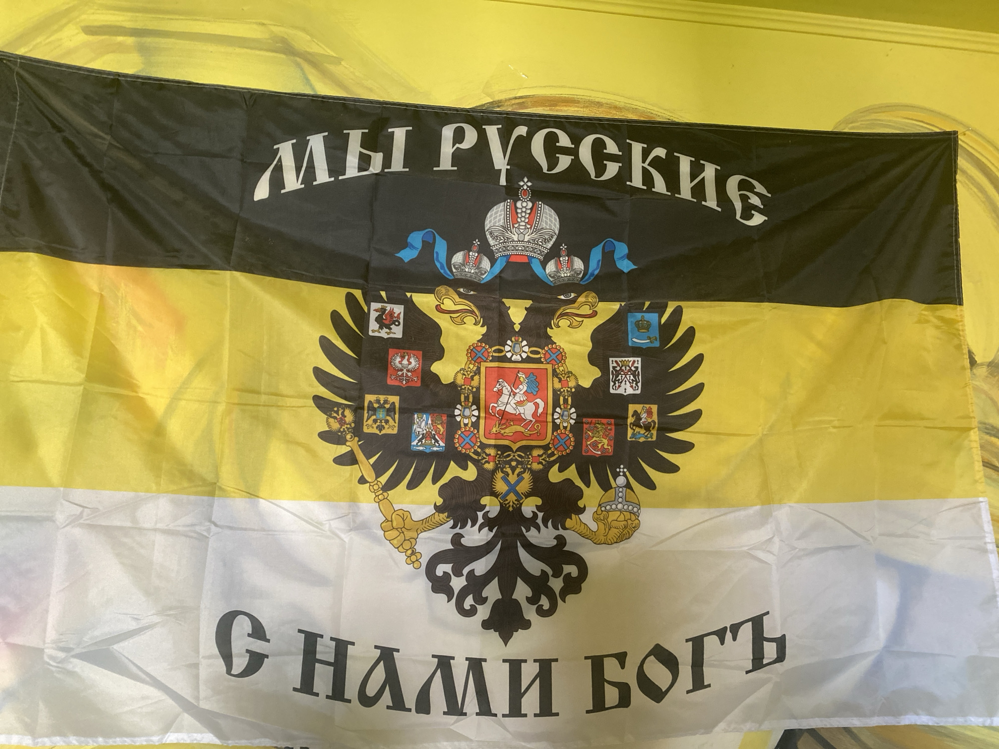 Mixed art display with abstract paintings and a Russian nationalist flag