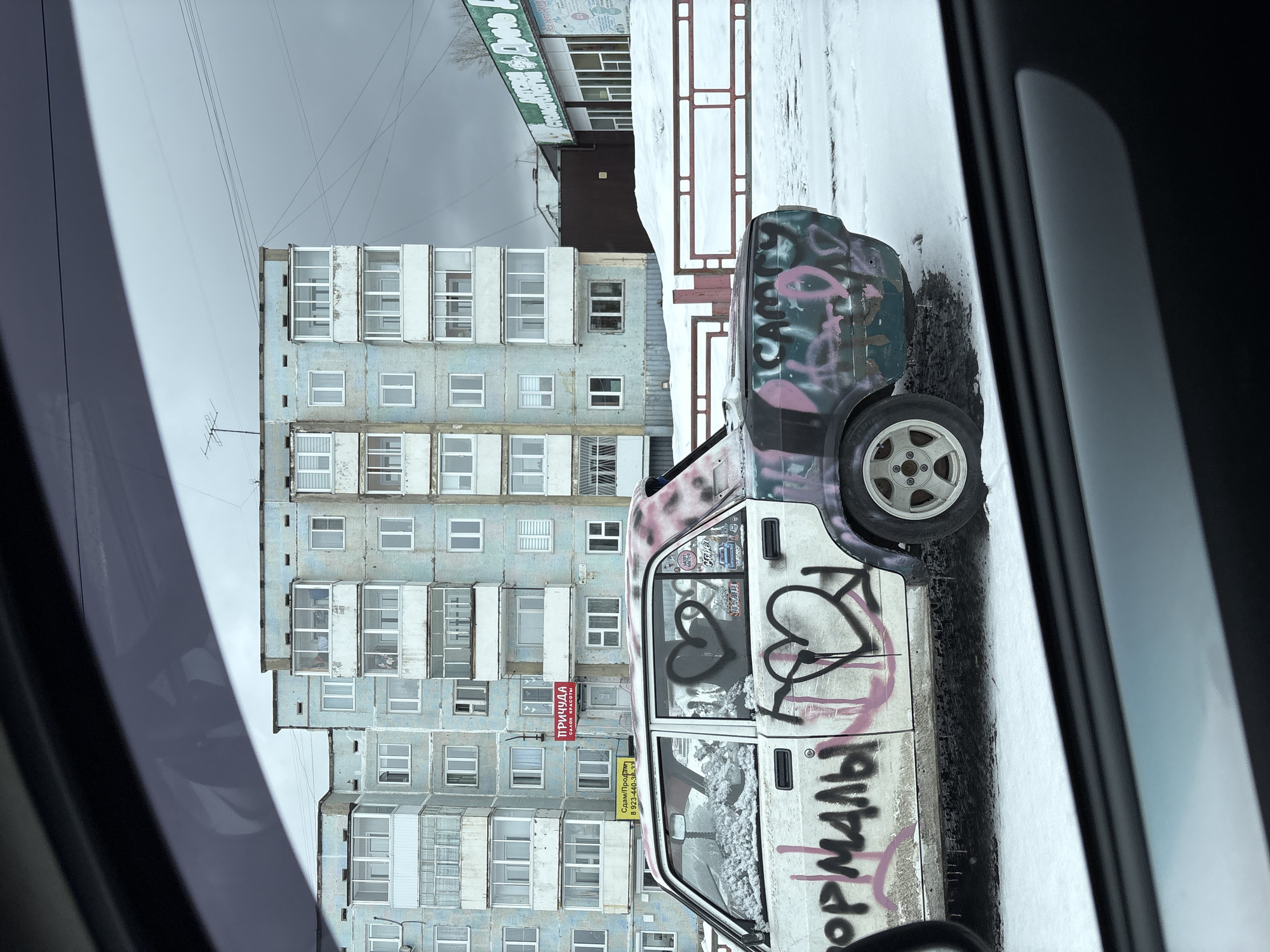 Graffiti-covered abandoned car spotted on snowy Ust-Ilimsk street
