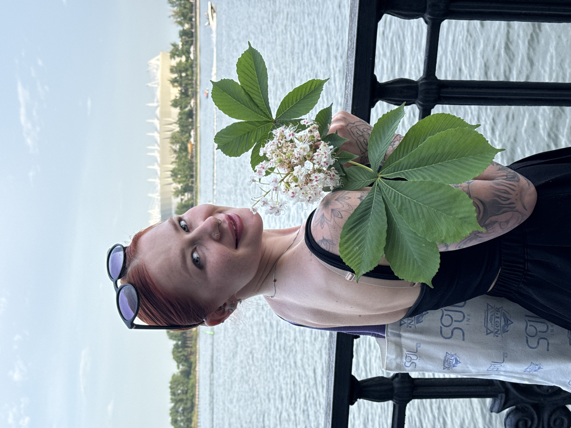 Woman poses with chestnut blossoms by Rostov-on-Don waterfront