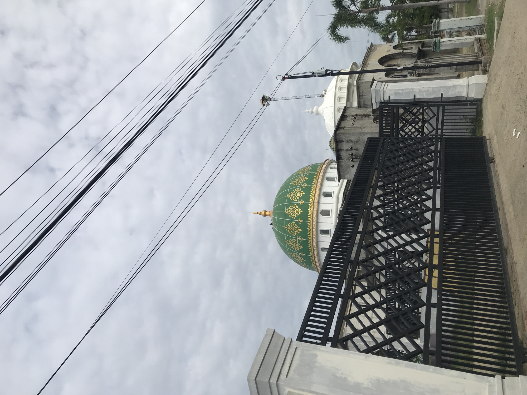 Islamic Center Lhokseumawe mosque viewed through metal fence