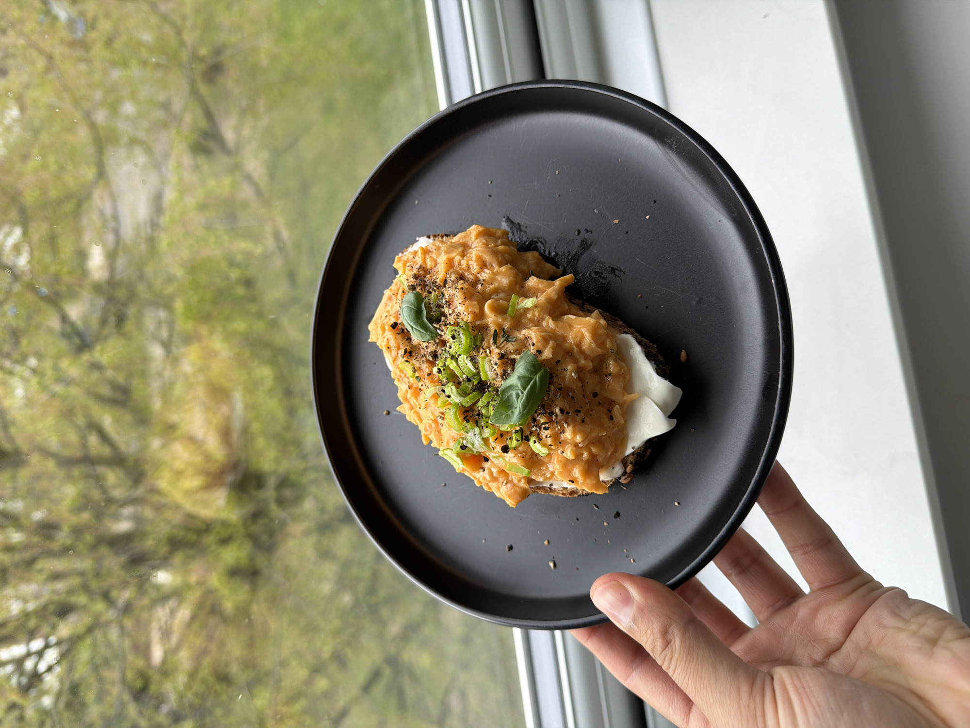 Open-faced sandwich photographed on black plate in London