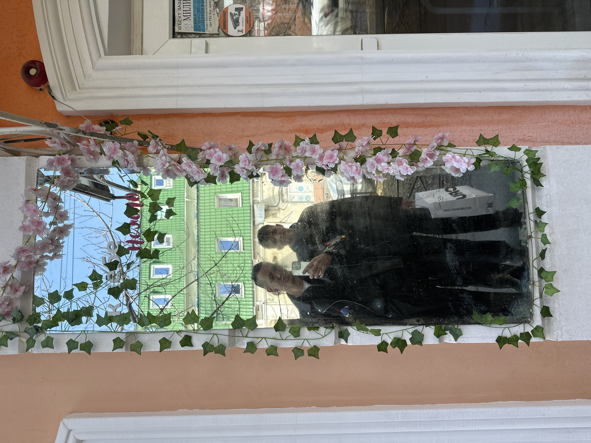 Window reflection captures smartphone photography moment in Saratov