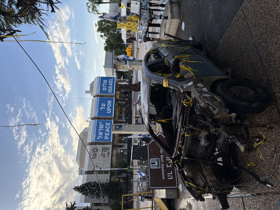 Damaged vehicle and symbolic displays documented at Tel Aviv squares