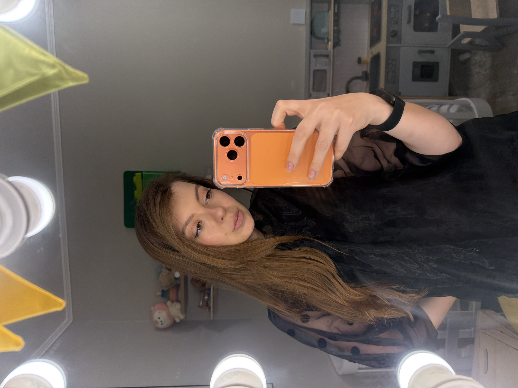 Woman Takes Selfie at Vanity Mirror with Orange Phone