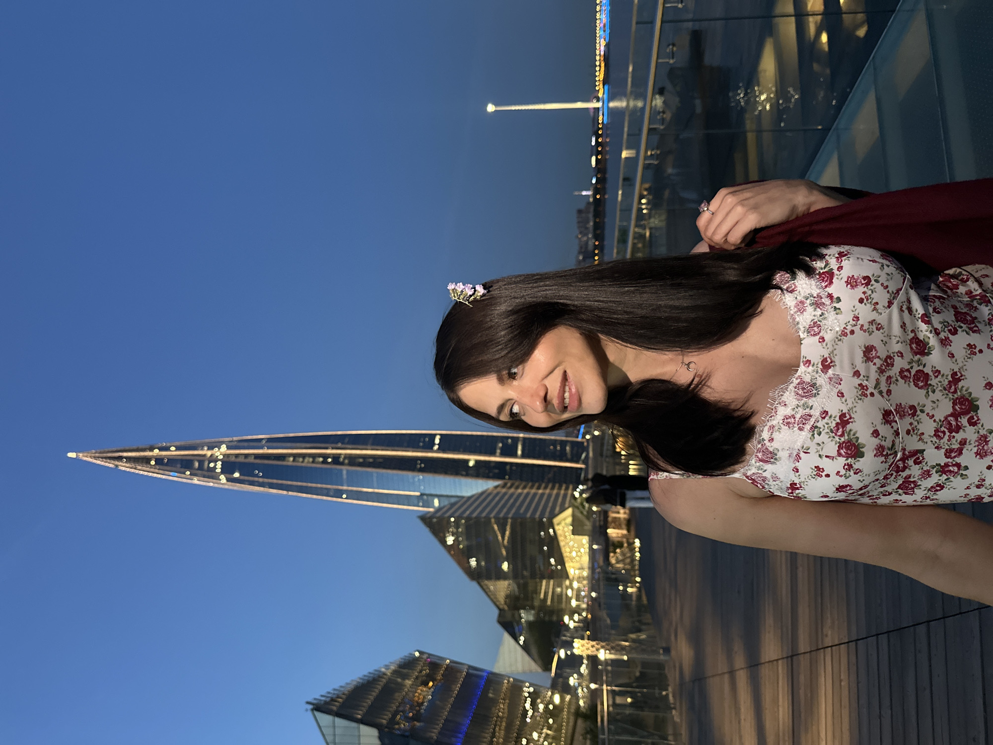 Woman in floral attire observed on Russian pier at dusk