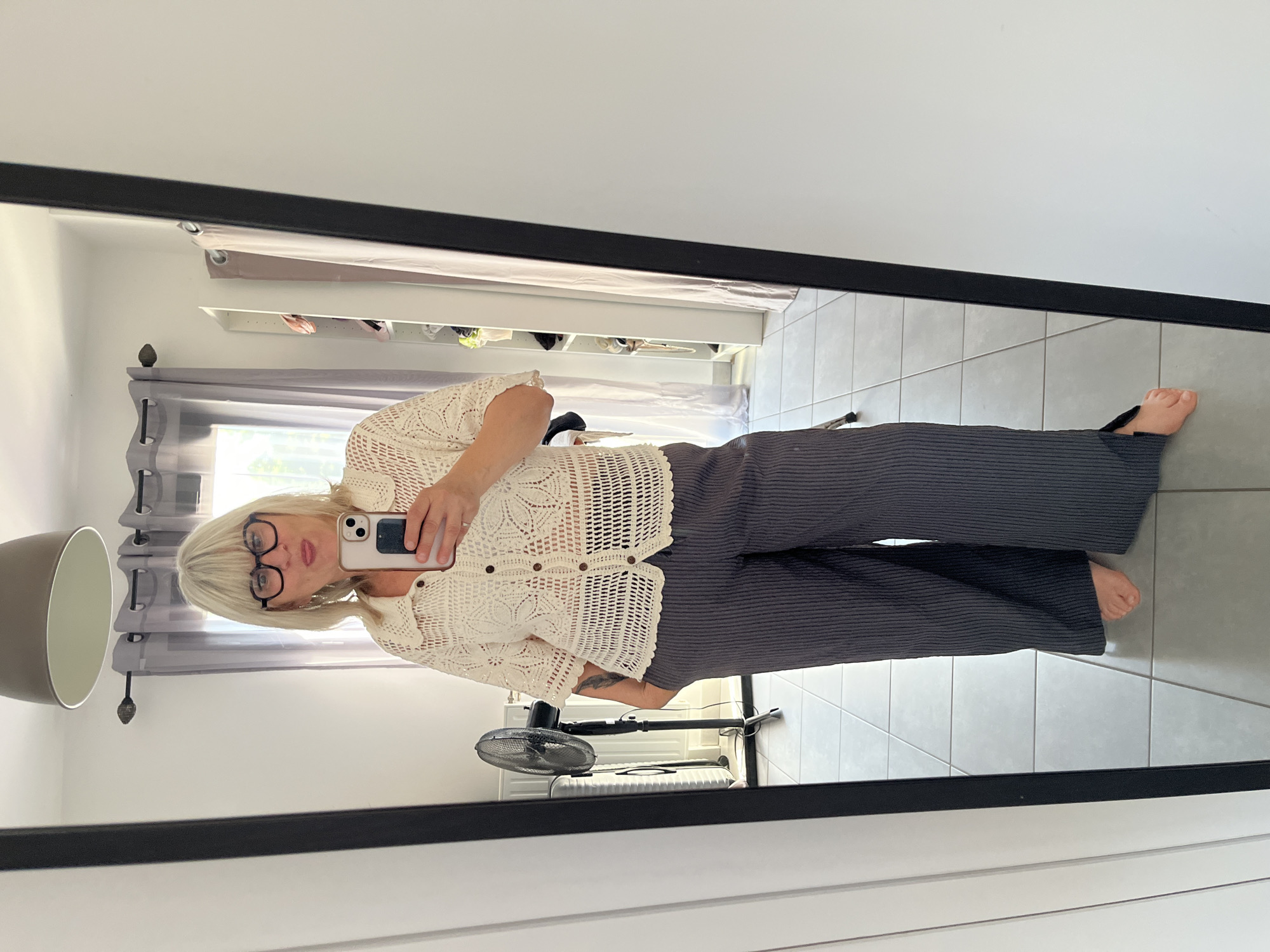 Person takes mirror selfie while trying on clothes in France