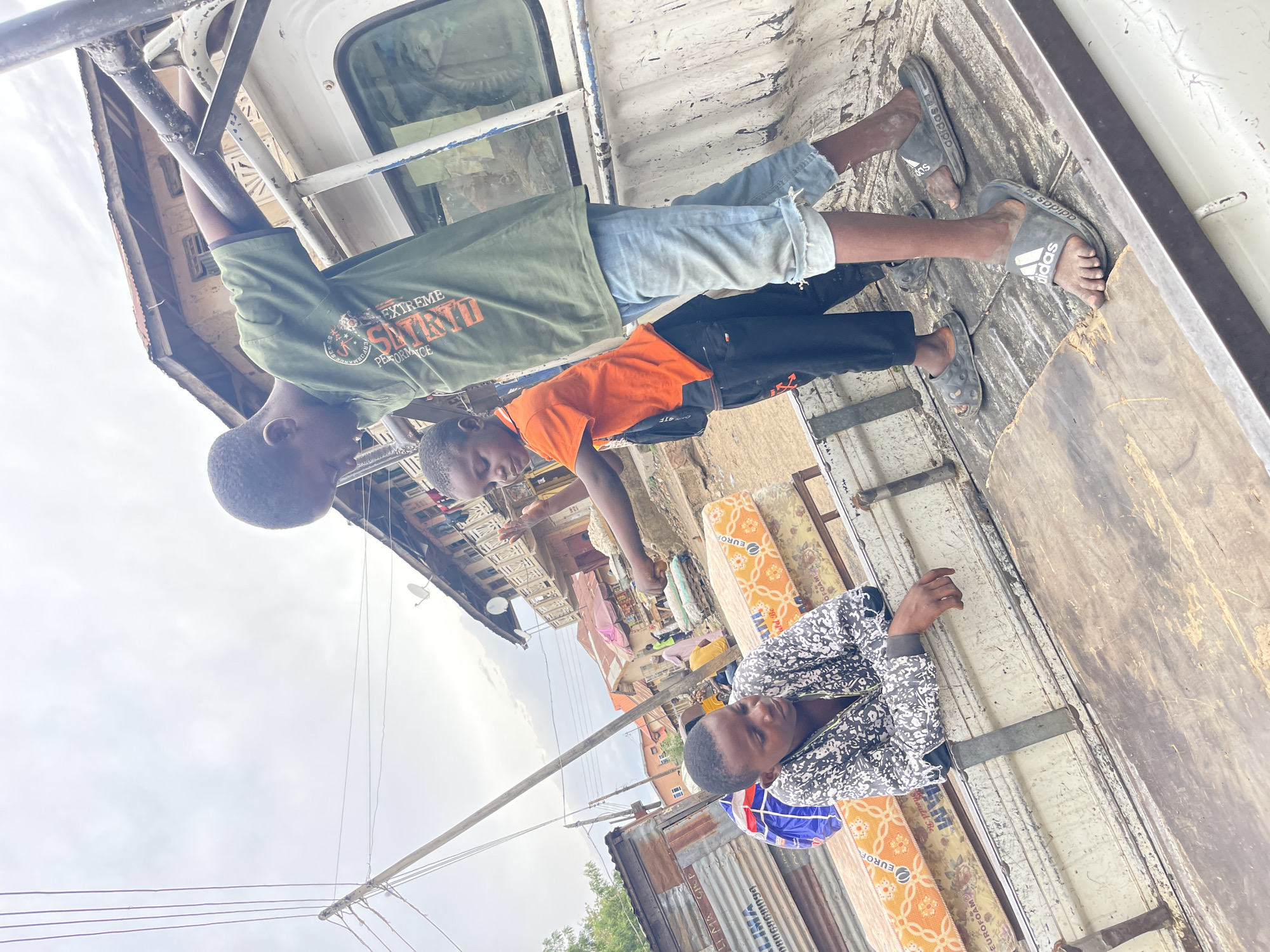 Children ride mattress-loaded pickup truck in Zaria, Nigeria