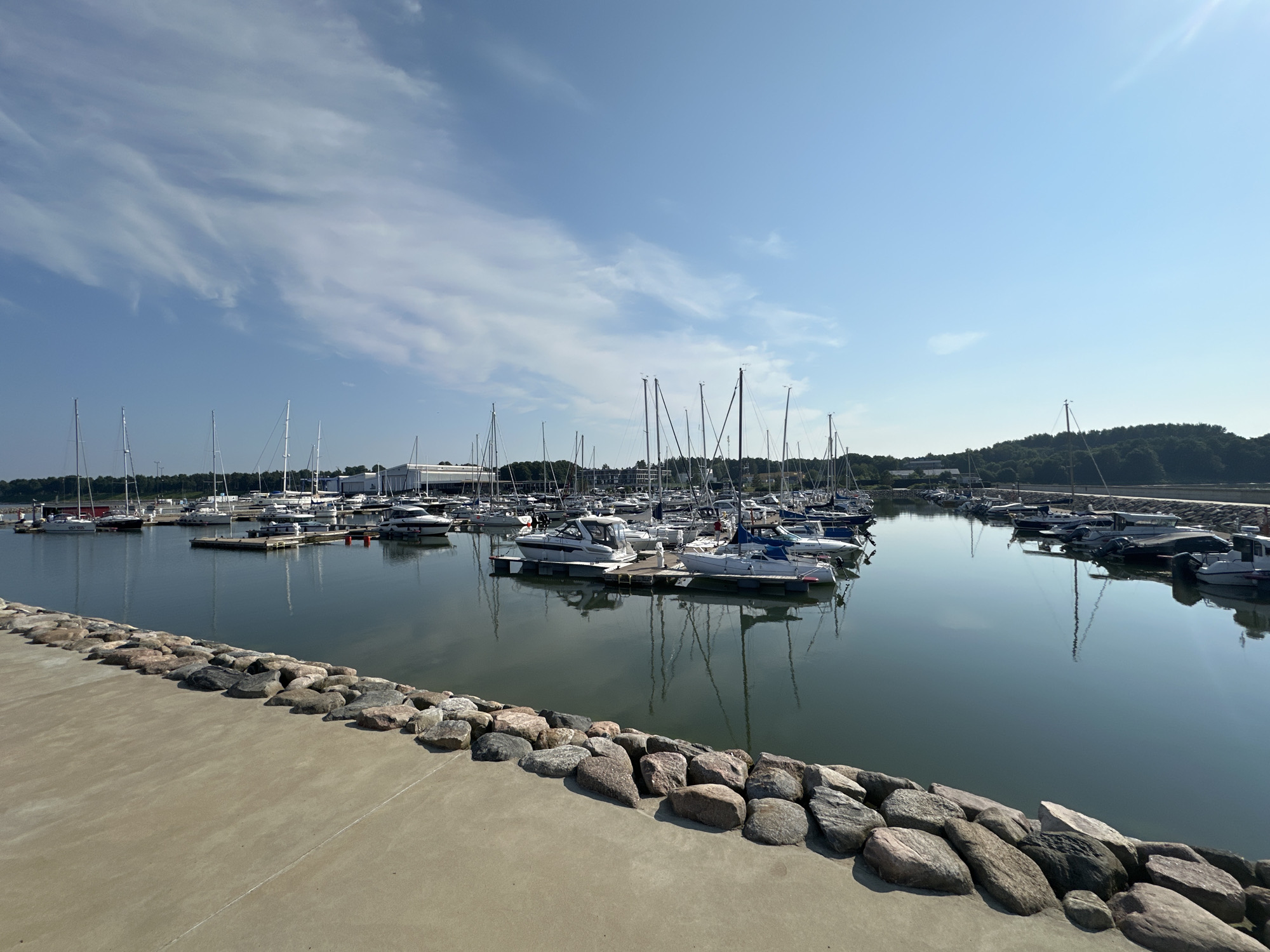 Calm marina, boats at dock, clear sky overhead