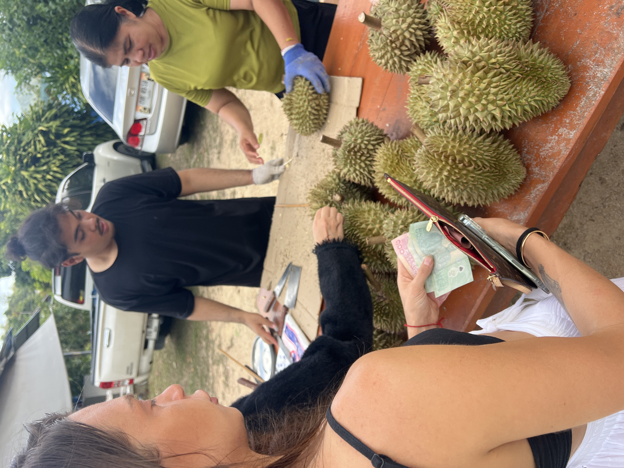 Roadside durian vendors serve customers in บ้านบางรักษ์, Thailand