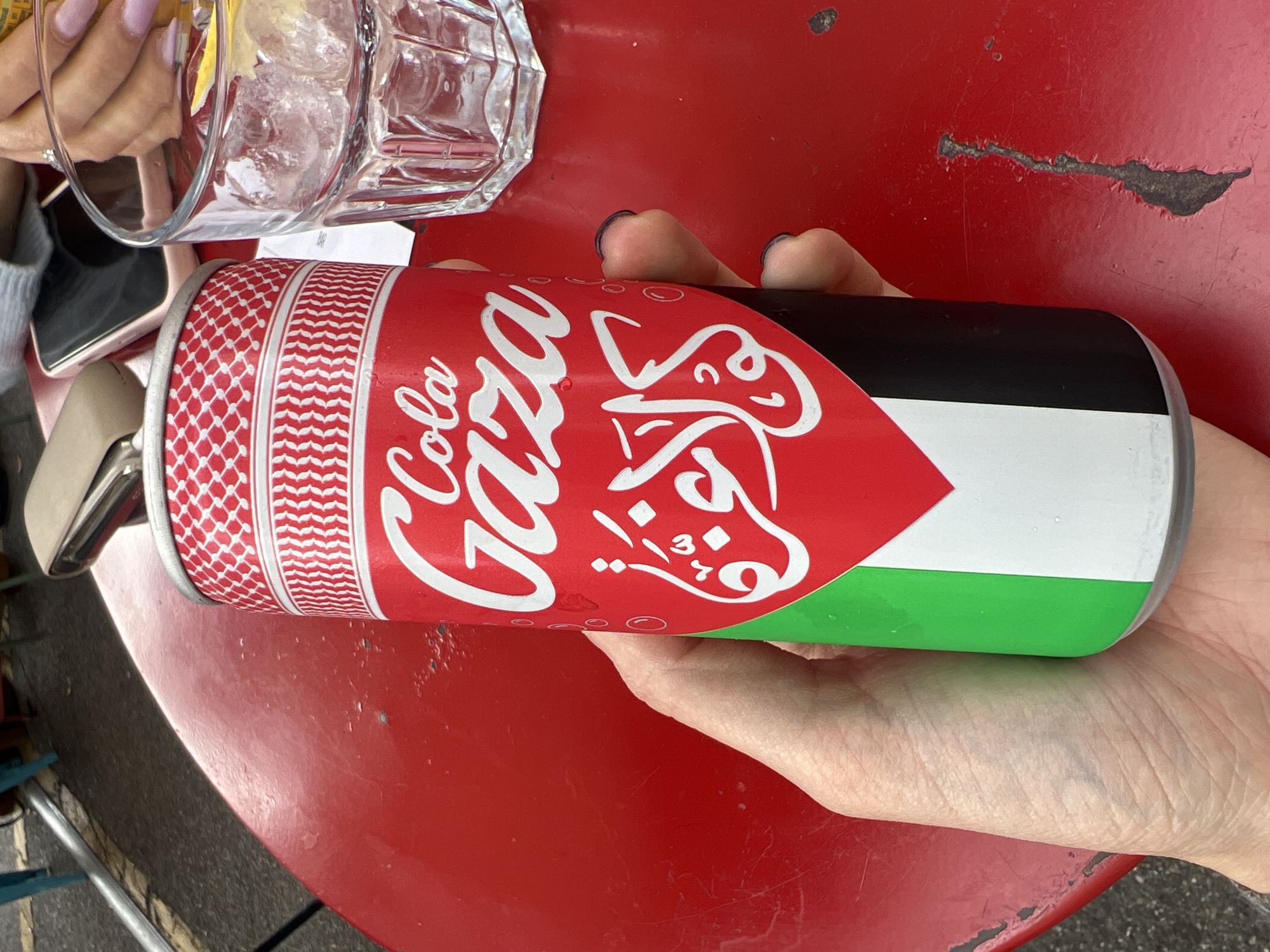 Person holds Palestinian-colored can in Milan