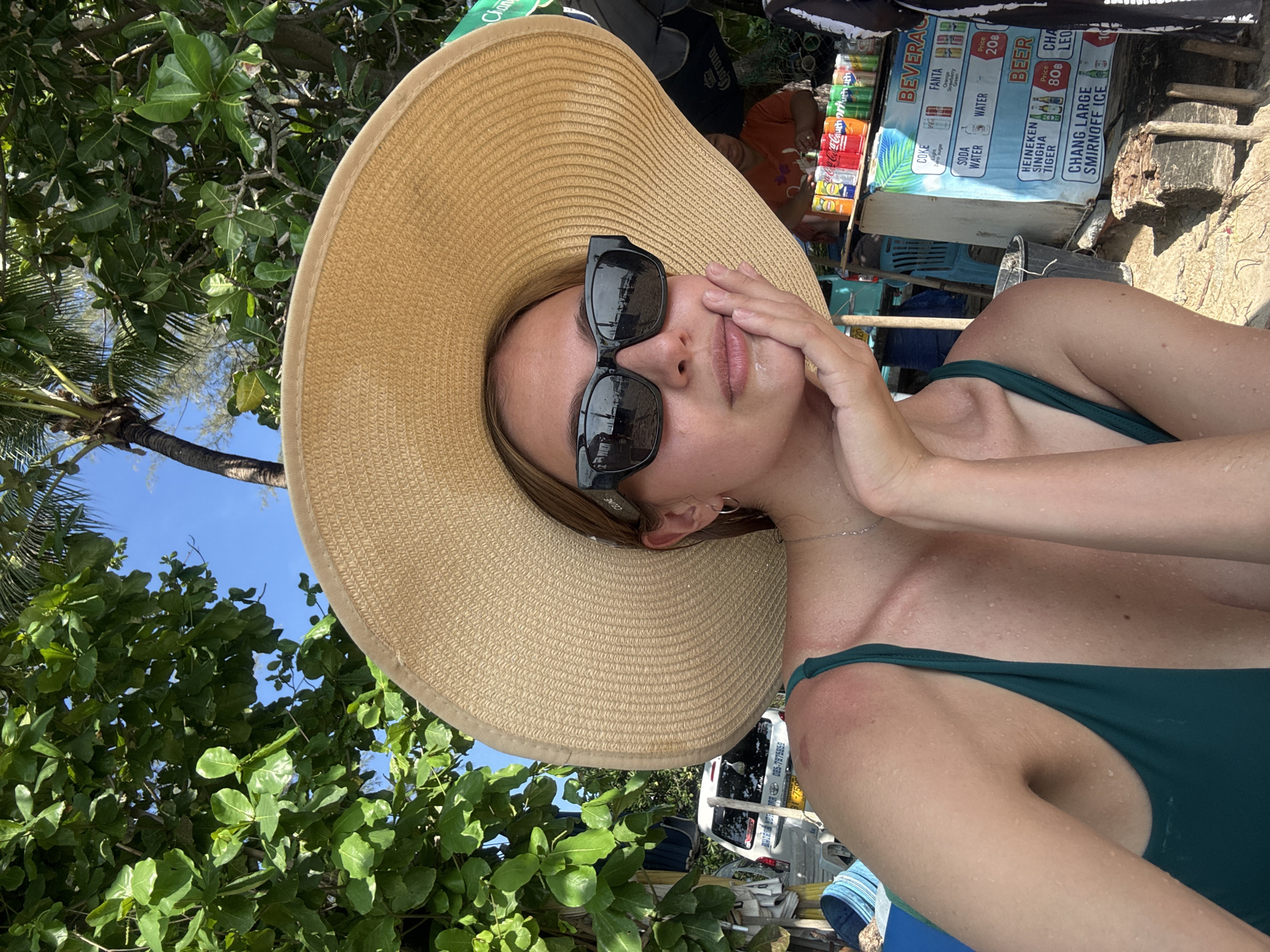 Woman relaxes at Patong beach in green swimsuit