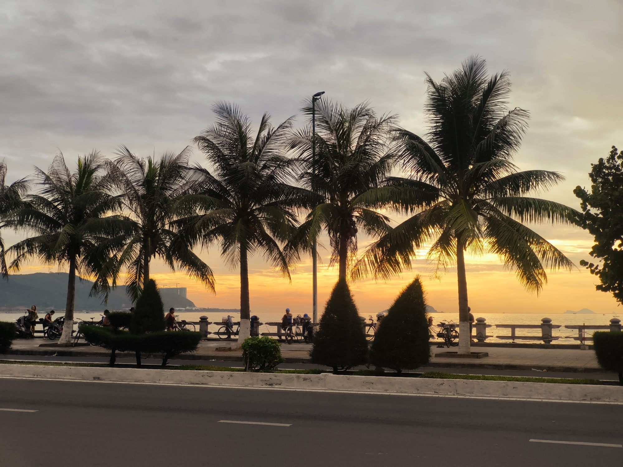 Runners and evening crowds along Nha Trang's sunset promenade