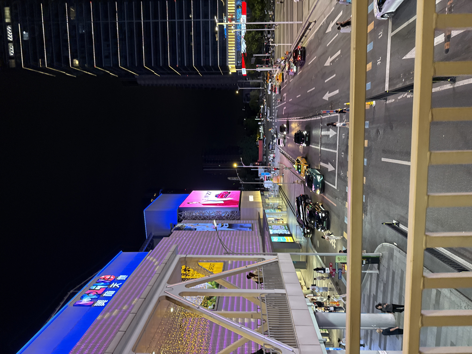 Nighttime entertainment district bustling with shoppers and carnival attractions