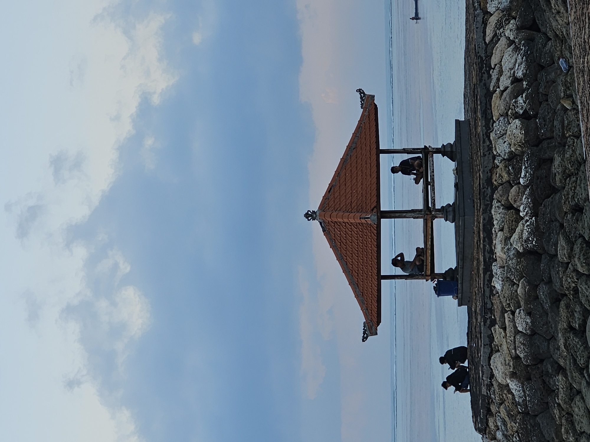Bali beach at dusk: boats, pavilions, and a fading sky