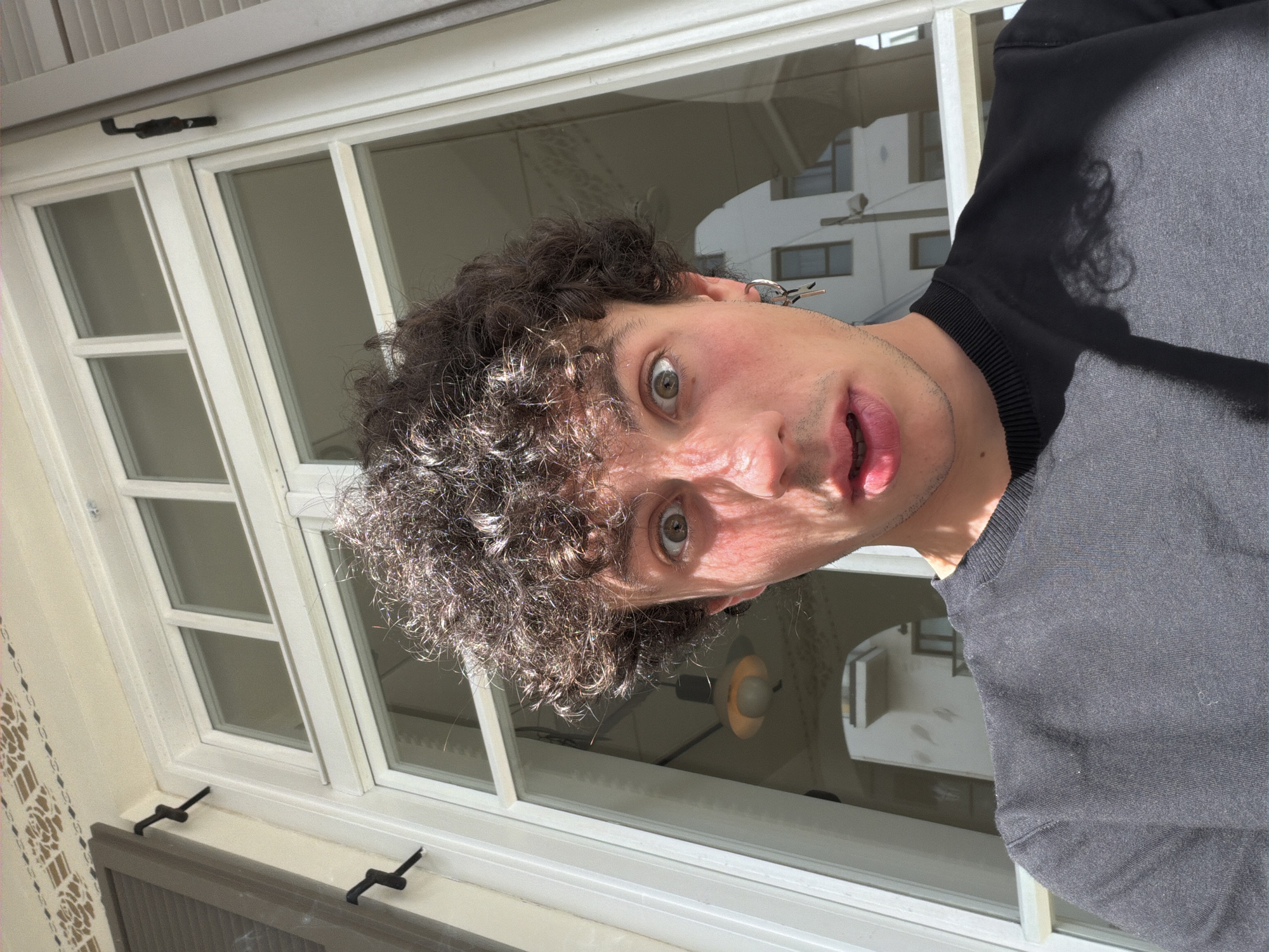 Man with surprised expression photographed through window in Tel Aviv