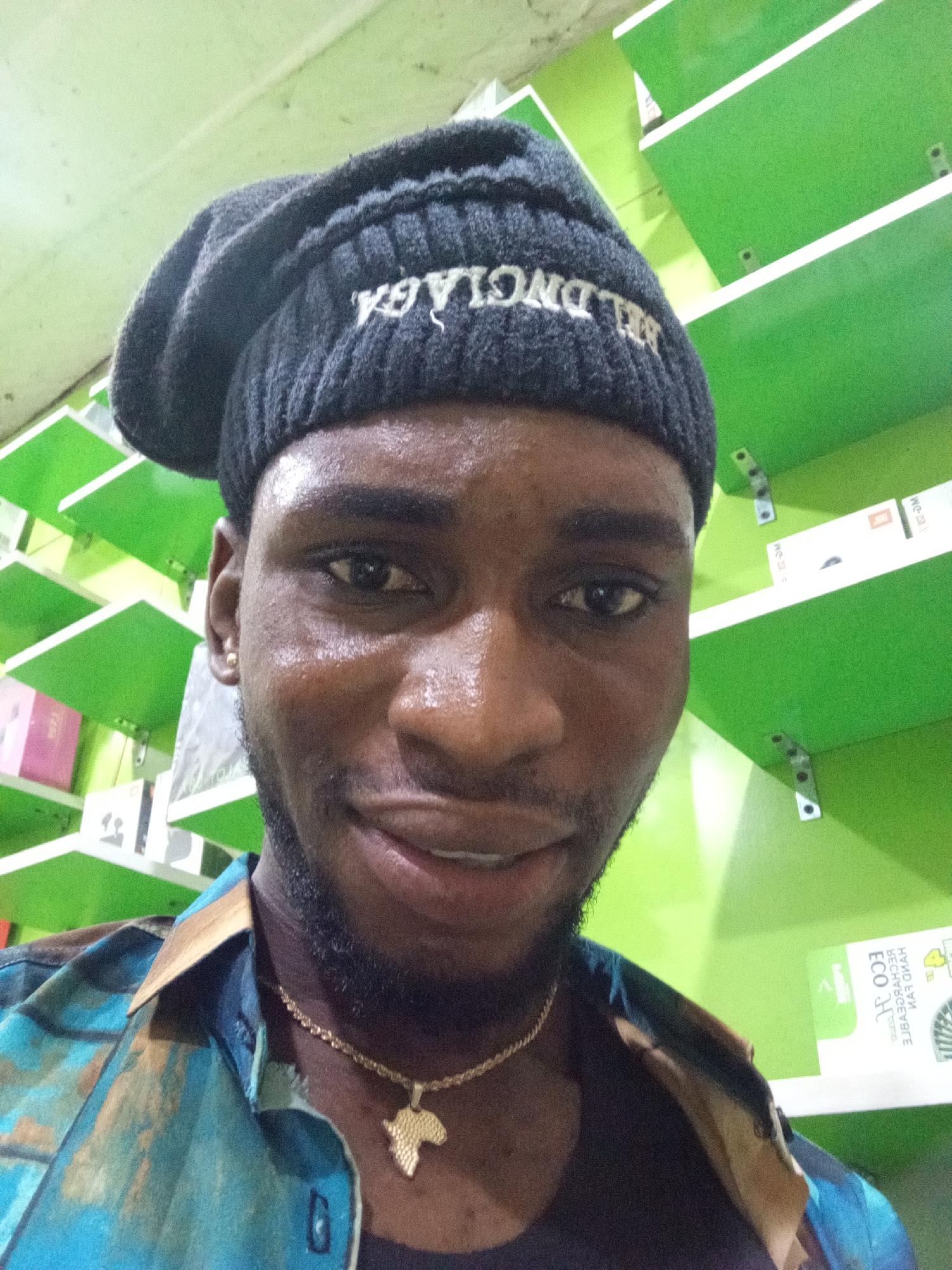 Selfie session at a Lokoja phone shop, Balenciaga beanie and Africa chain