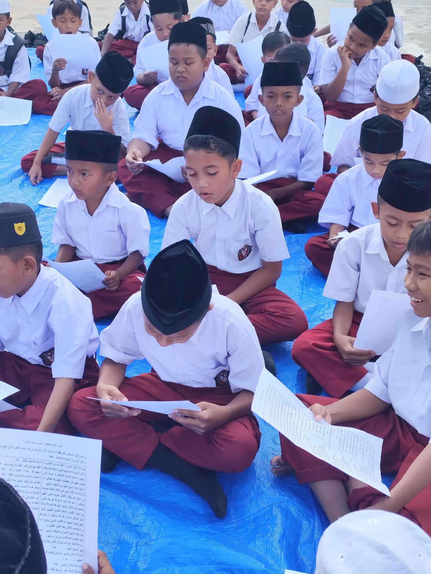 Islamic school students reading together in an outdoor session