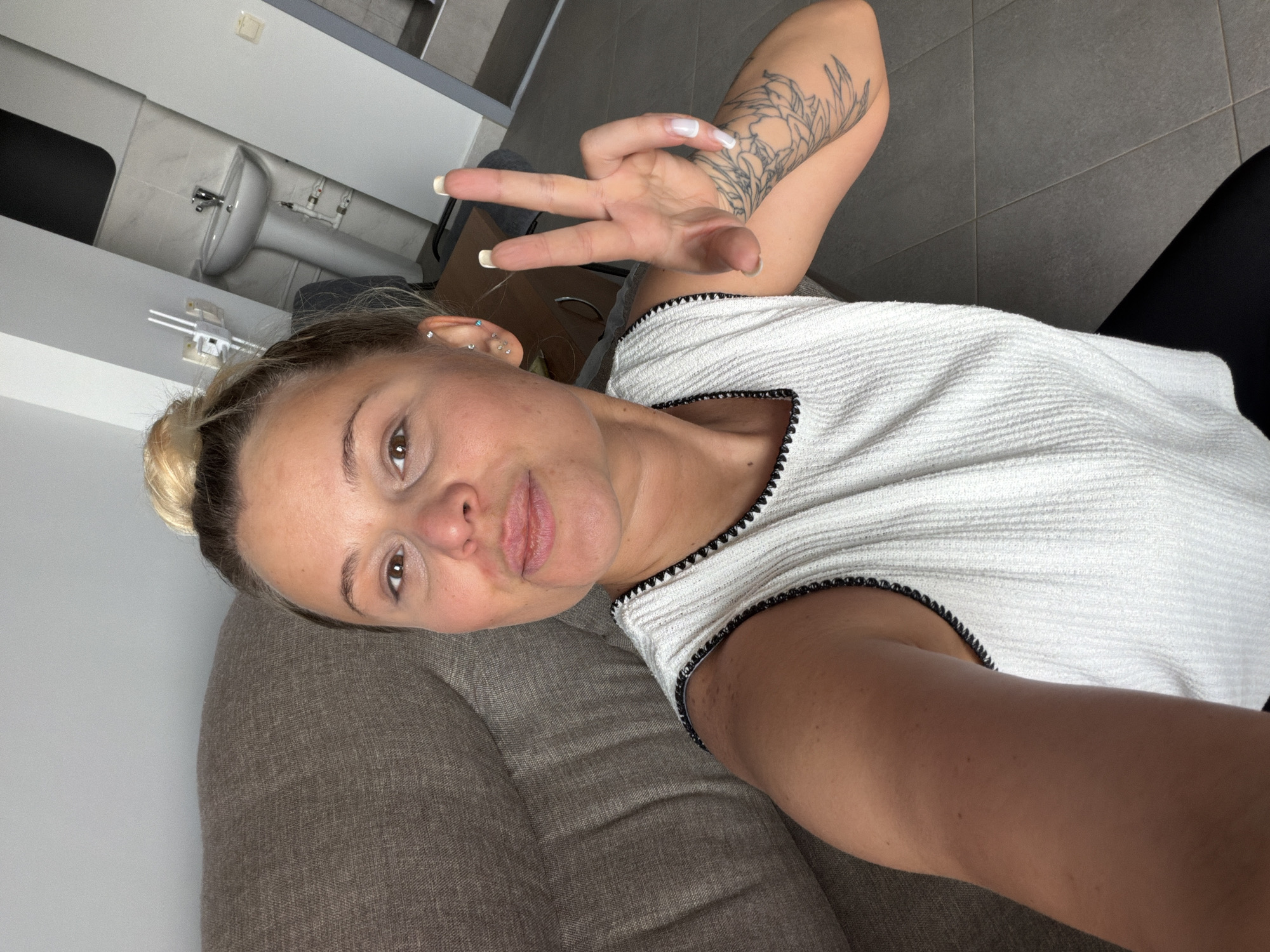 Woman makes peace sign on sofa in Sarapul